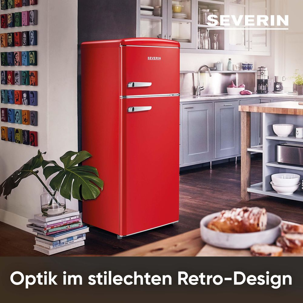 Ein roter Retro-Kühlschrank steht in einer Küche. An der Wand hängen Bilder.