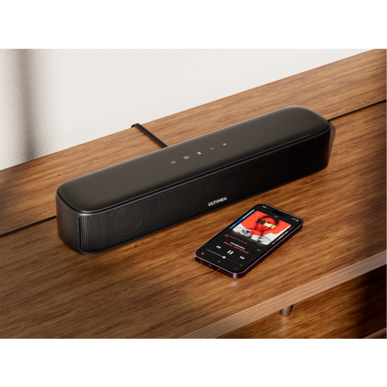Haut-parleur noir et smartphone avec application musicale sur table en bois.