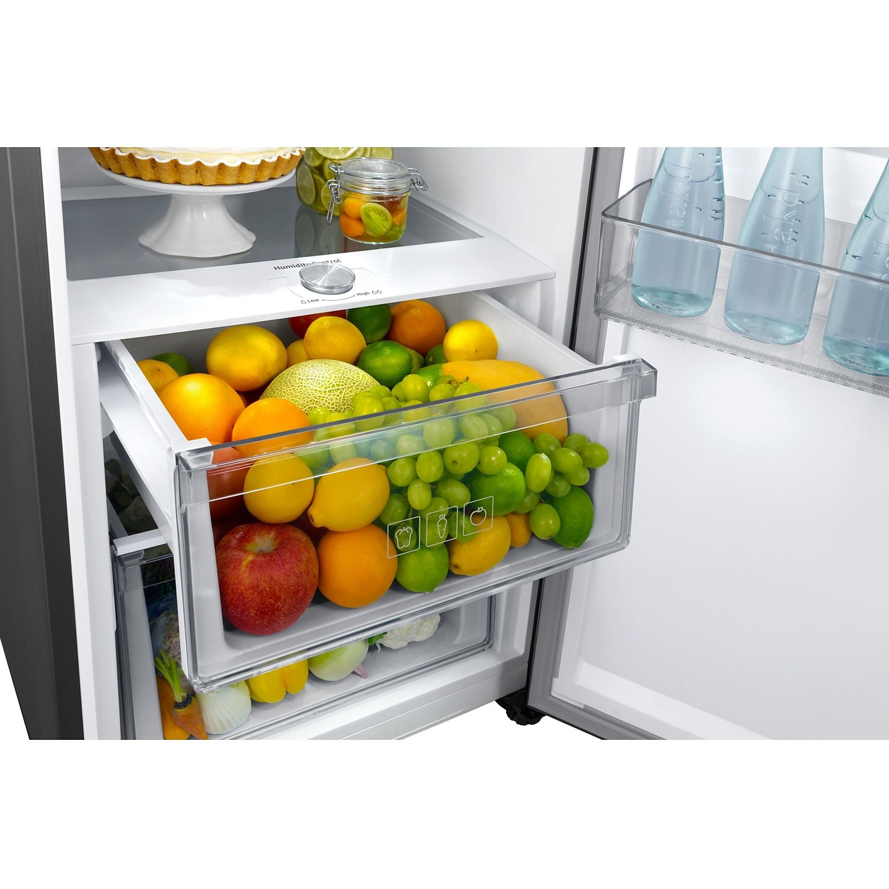 Un réfrigérateur ouvert avec des fruits et légumes dans des tiroirs et des bouteilles dans le compartiment de la porte.