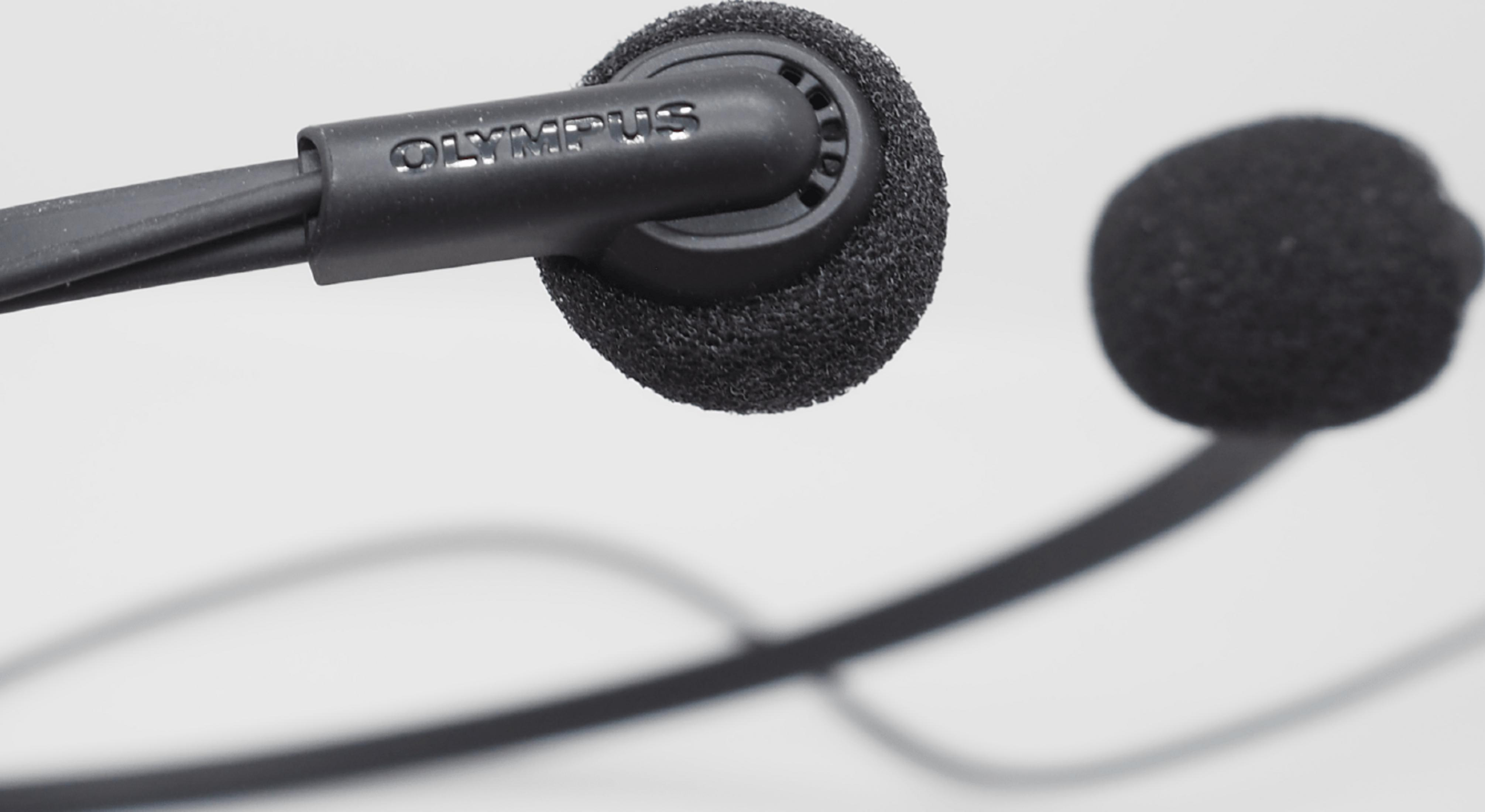 Primo piano di auricolari Olympus neri con coperture in schiuma e cavo su sfondo bianco.