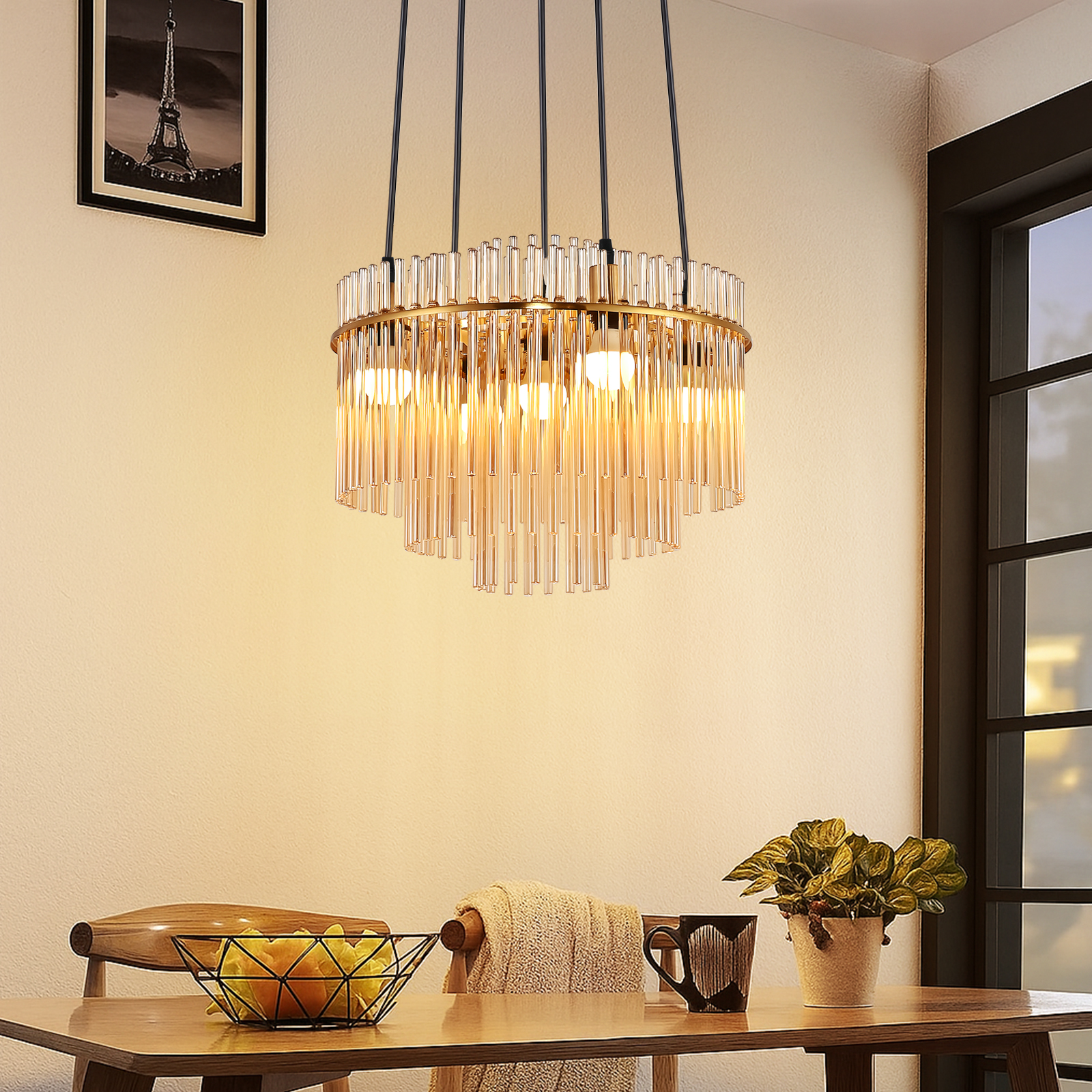 Candelabro de varillas de vidrio y metal sobre mesa de madera con fruta y planta.