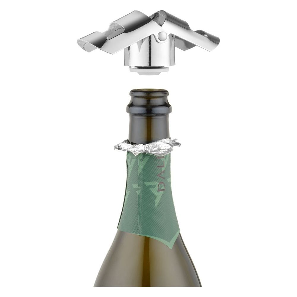 Un tappo d'argento per champagne sopra una bottiglia con etichetta verde e collare di stagnola.