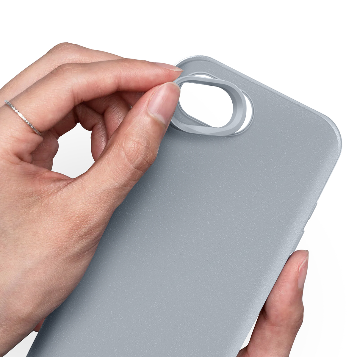 Una mano con un anillo quita un anillo gris de una funda de teléfono.