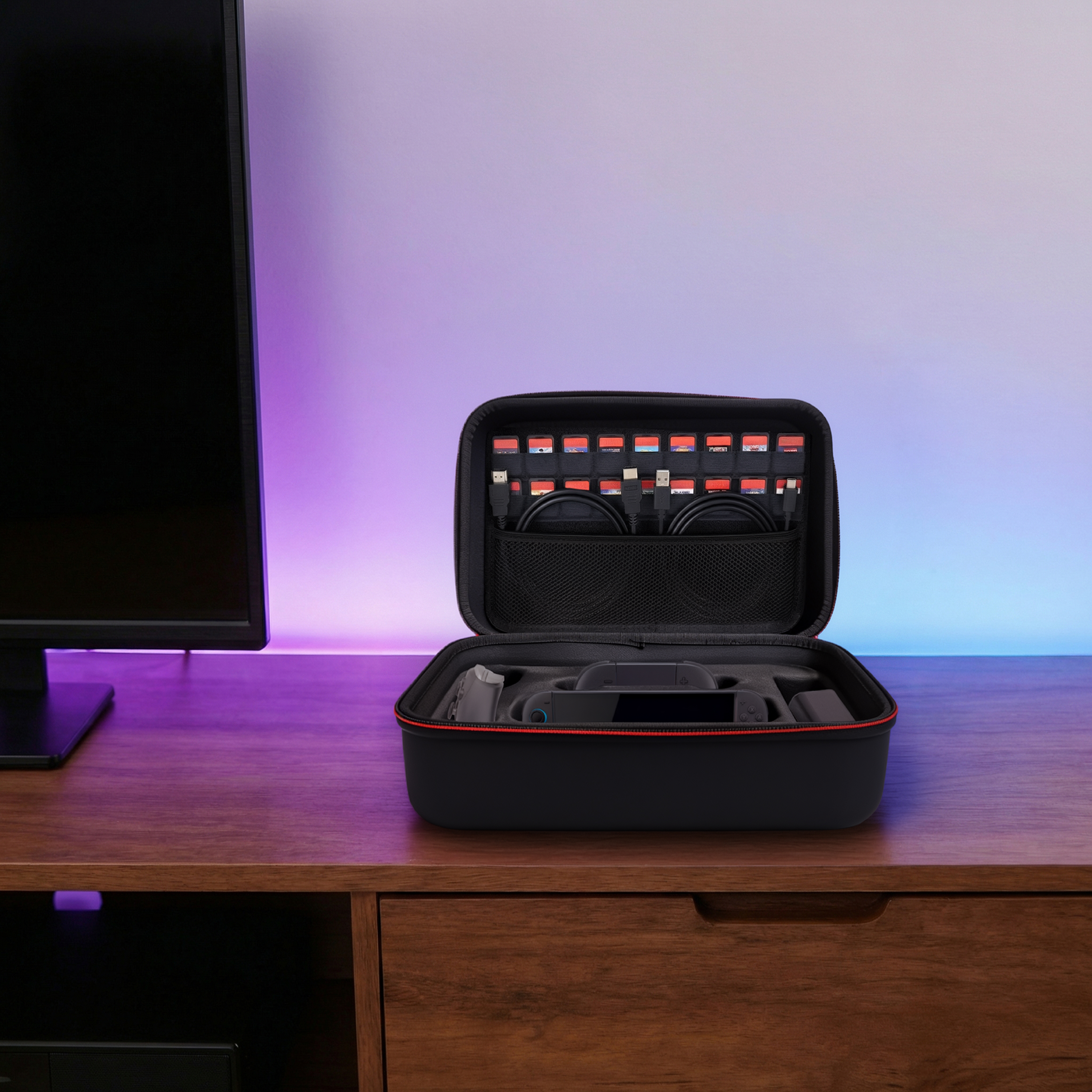 Une mallette noire pour électronique est ouverte sur un bureau en bois. Elle contient des manettes.