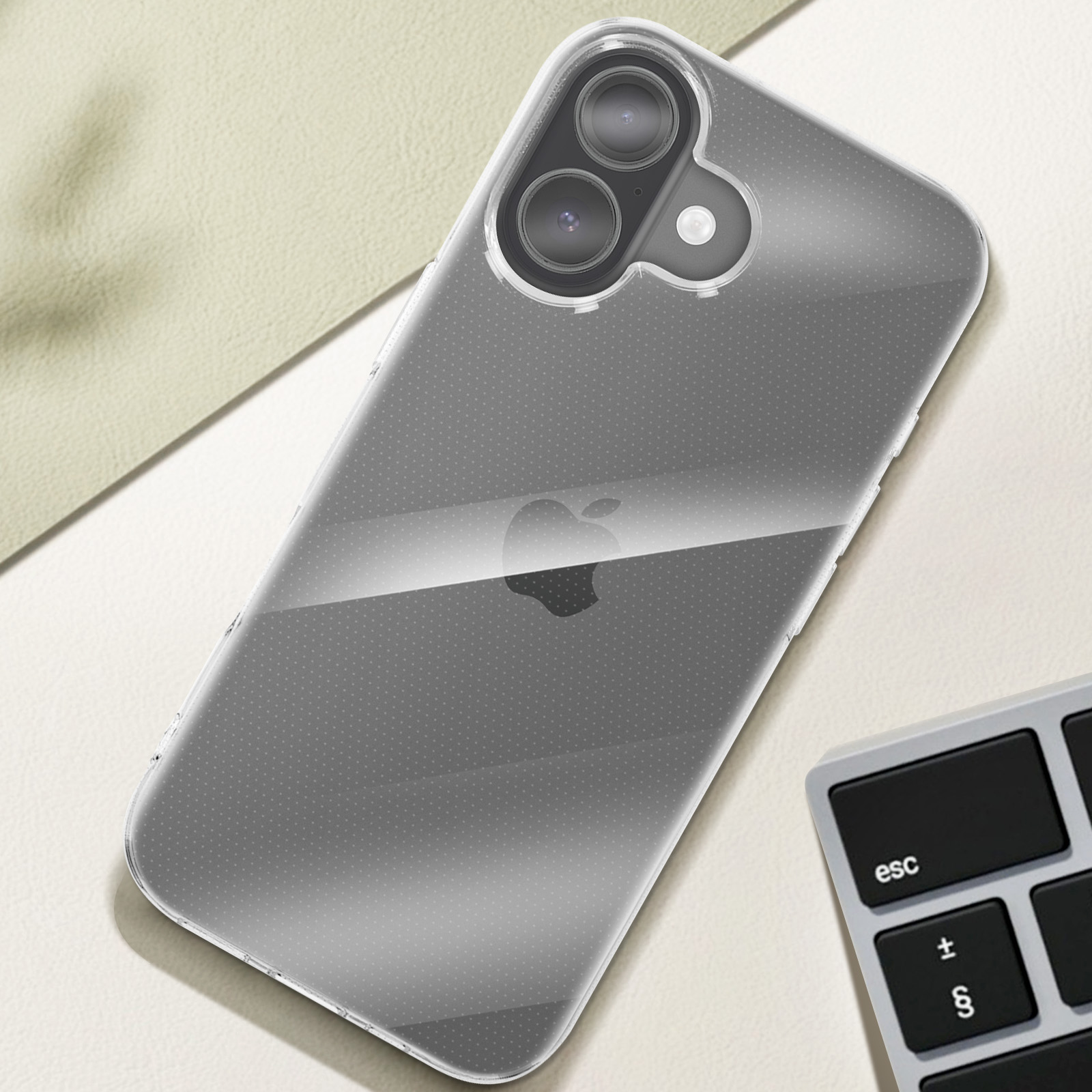 Een doorzichtige telefoon met dubbele camera ligt op een crème oppervlak naast een toetsenbord.
