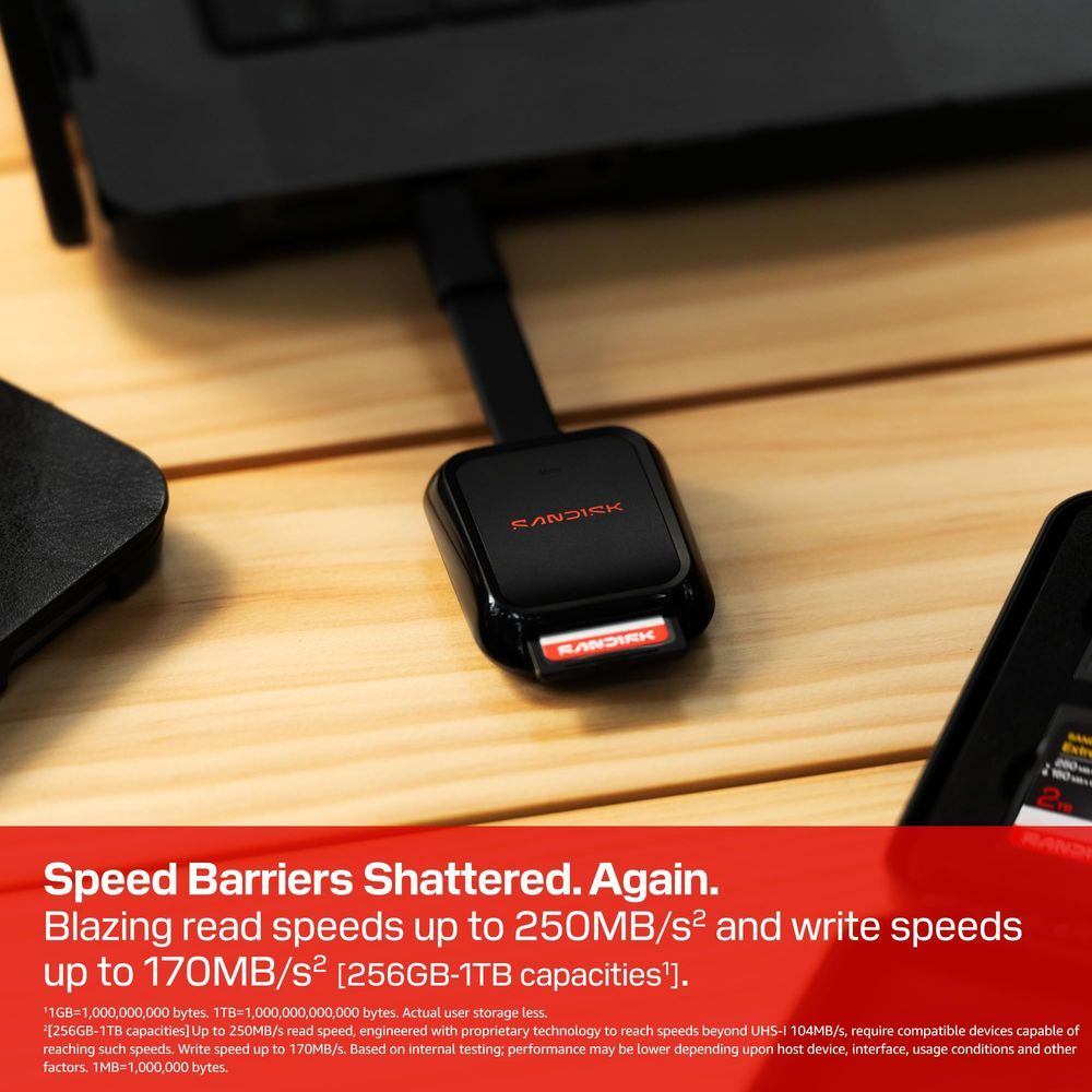 Un lecteur de carte SanDisk noir avec une carte SD insérée, connecté à un ordinateur portable.