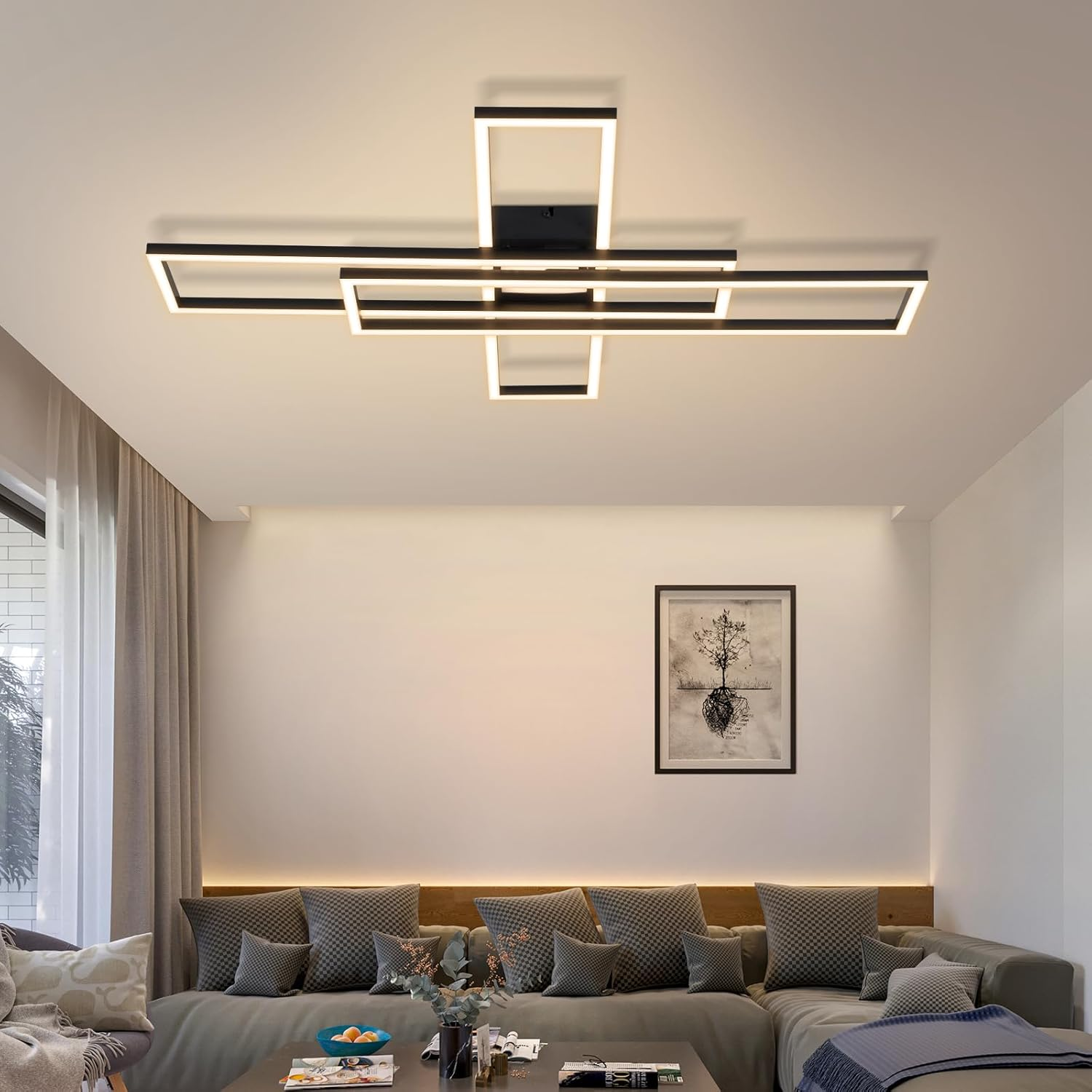 Moderna lámpara de techo rectangular negra con LEDs integrados sobre un sofá seccional.