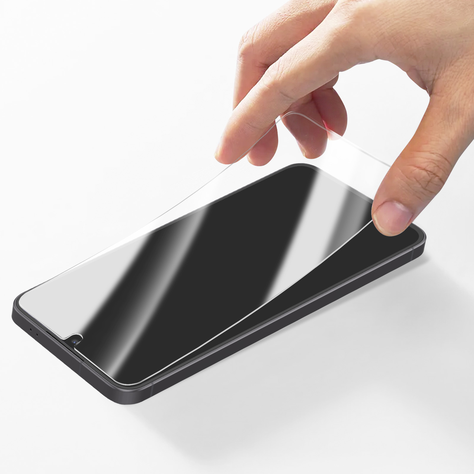 Une main pose un protecteur d'écran sur un smartphone.