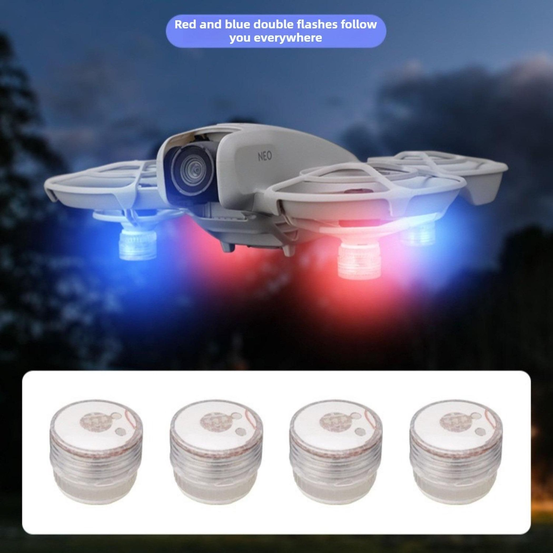 Ein weißer Quadrocopter mit roten und blauen Lichtern fliegt nachts. Unten sind vier Lichter.