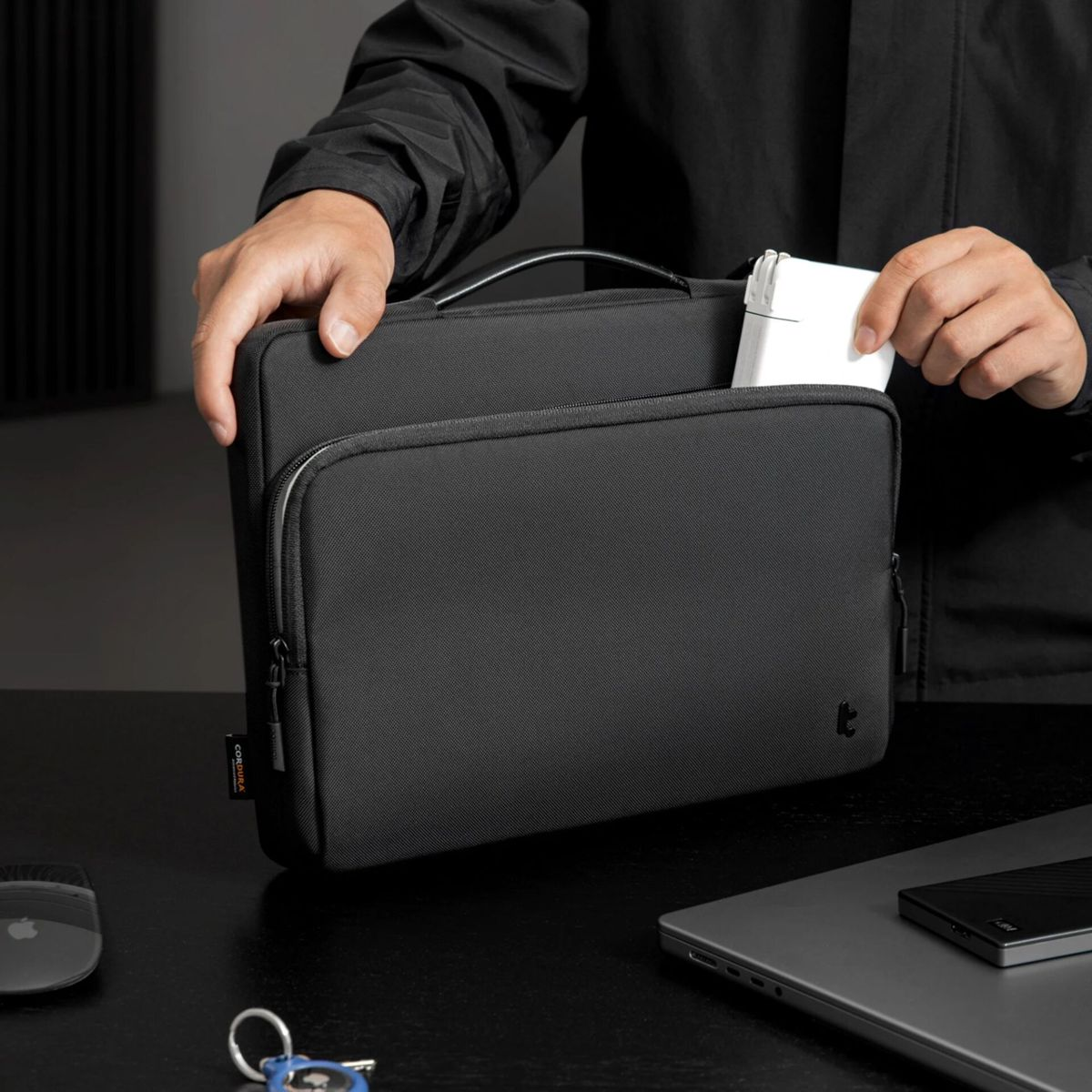 Borsa nera con oggetto bianco. Una persona la sta inserendo.