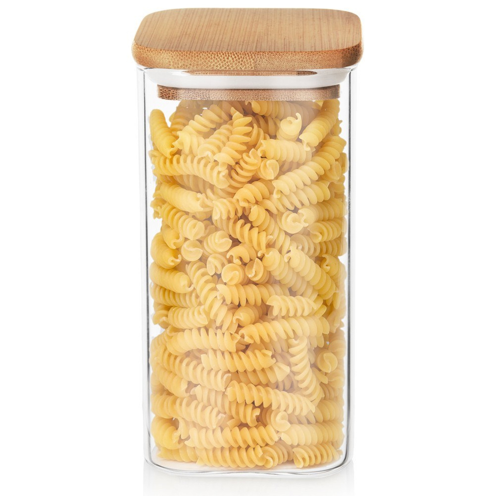 Un barattolo di vetro pieno di pasta fusilli e coperchio in legno.