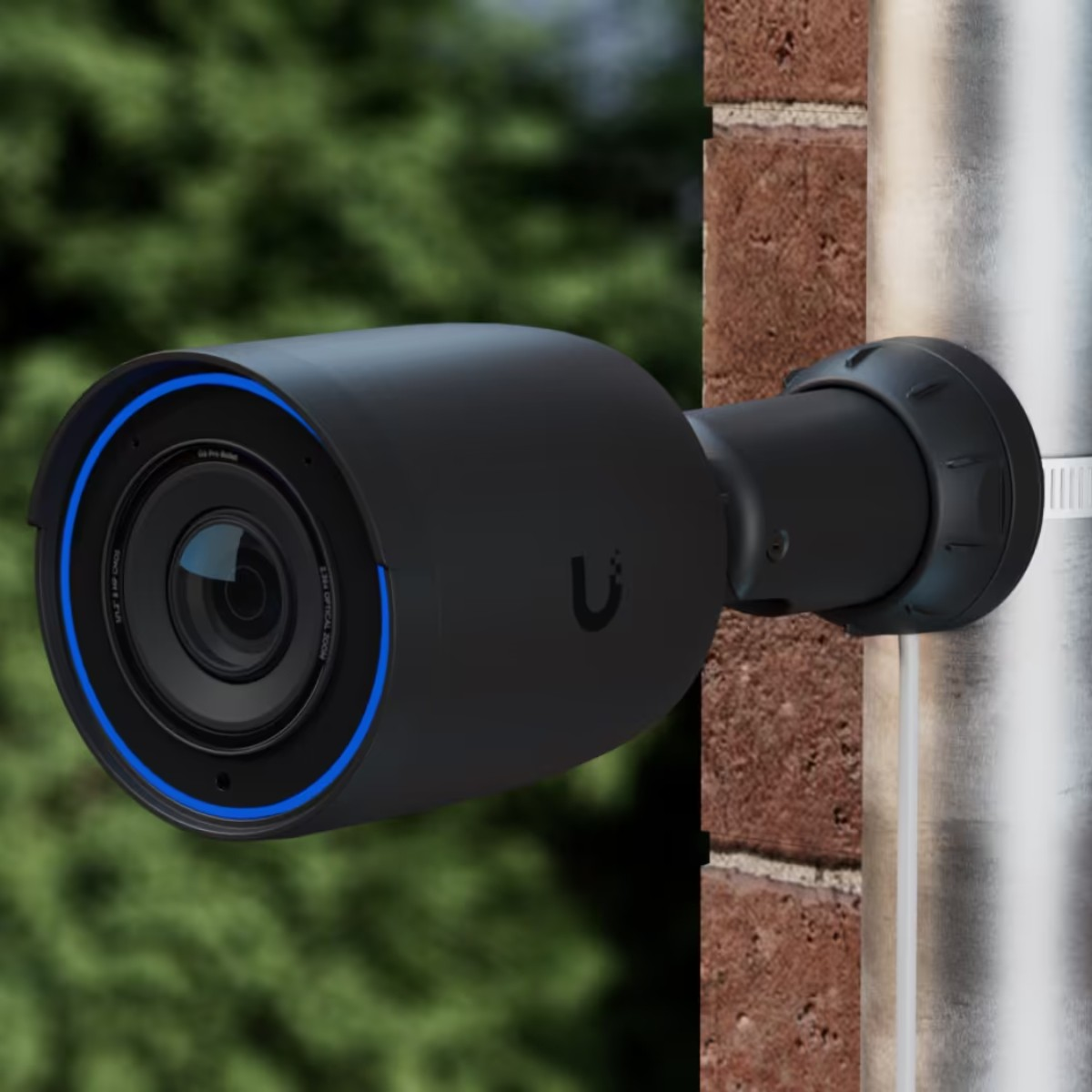 A black security camera with a blue ring is mounted on a metal pole.