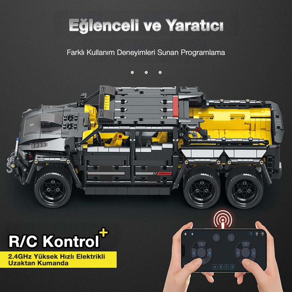 Sarı ve gri yapboz kamyon, ellerde tutulan uzaktan kumandalı.