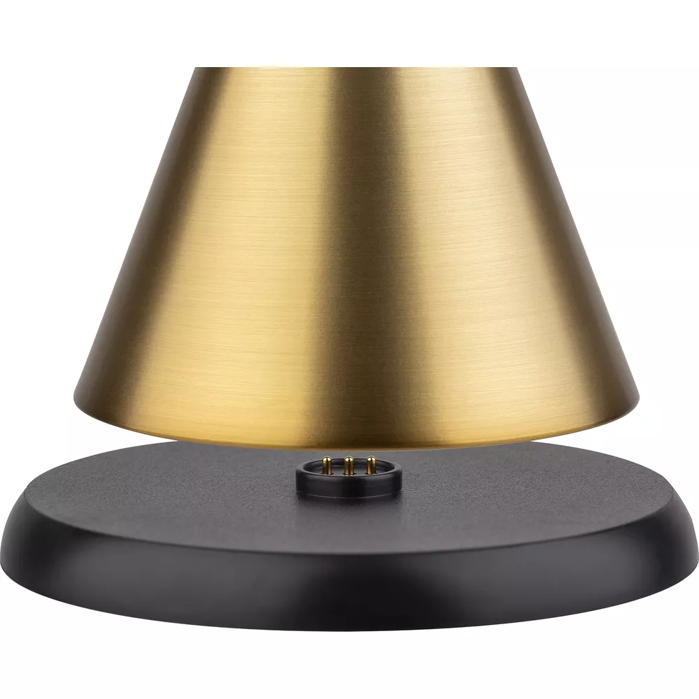 Ein goldener Lampenschirm mit einem schwarzen Sockel und Ladekontakten.