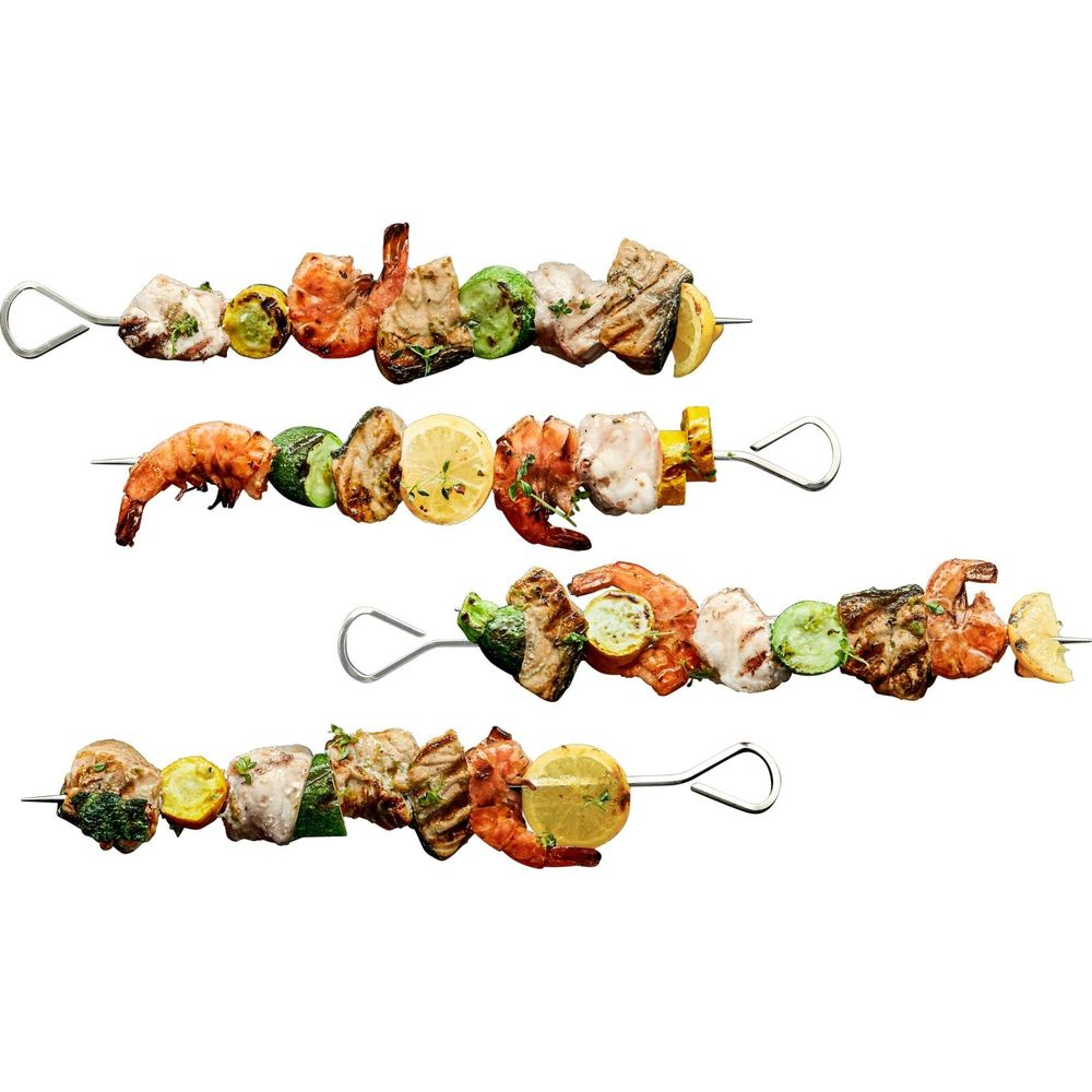 Vier Fleisch- und Garnelenspieße mit Zucchini, Zitrone und Kräutern auf weißem Hintergrund.
