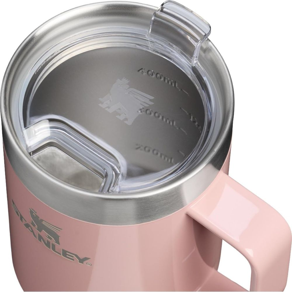 Primer plano de una taza Stanley rosa con tapa transparente y marcas de medición.