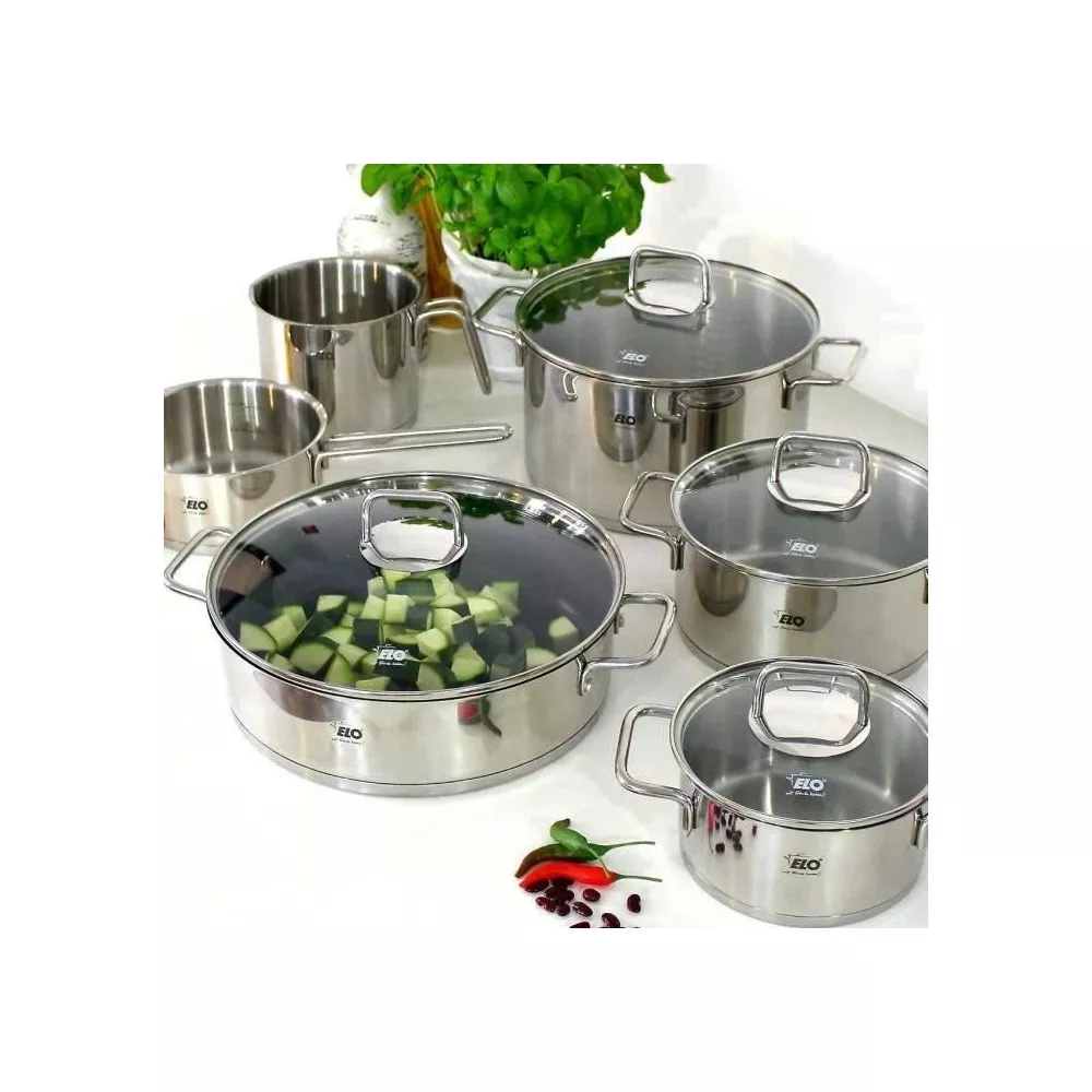 Ensemble d'ustensiles de cuisine en acier inoxydable avec couvercles, une casserole contient des courgettes coupées.