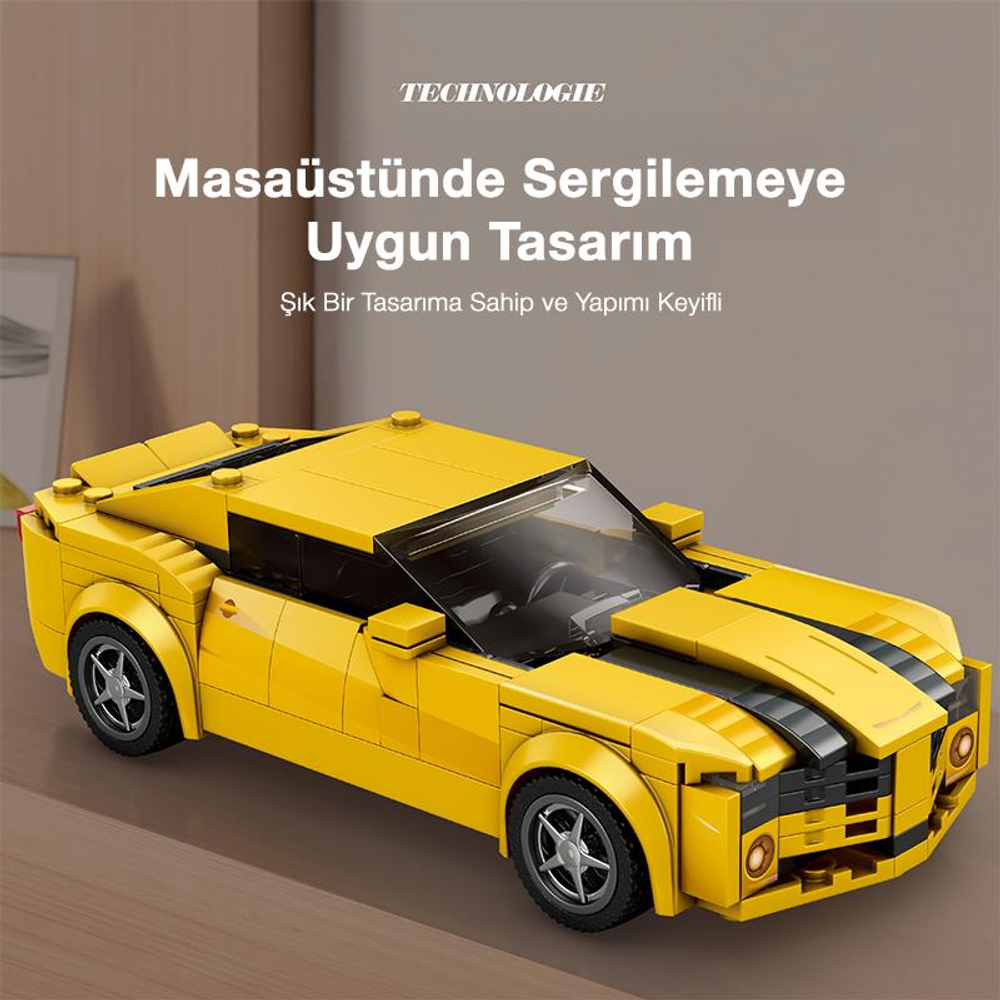 Siyah şeritli sarı bir Lego araba masanın üzerinde duruyor.