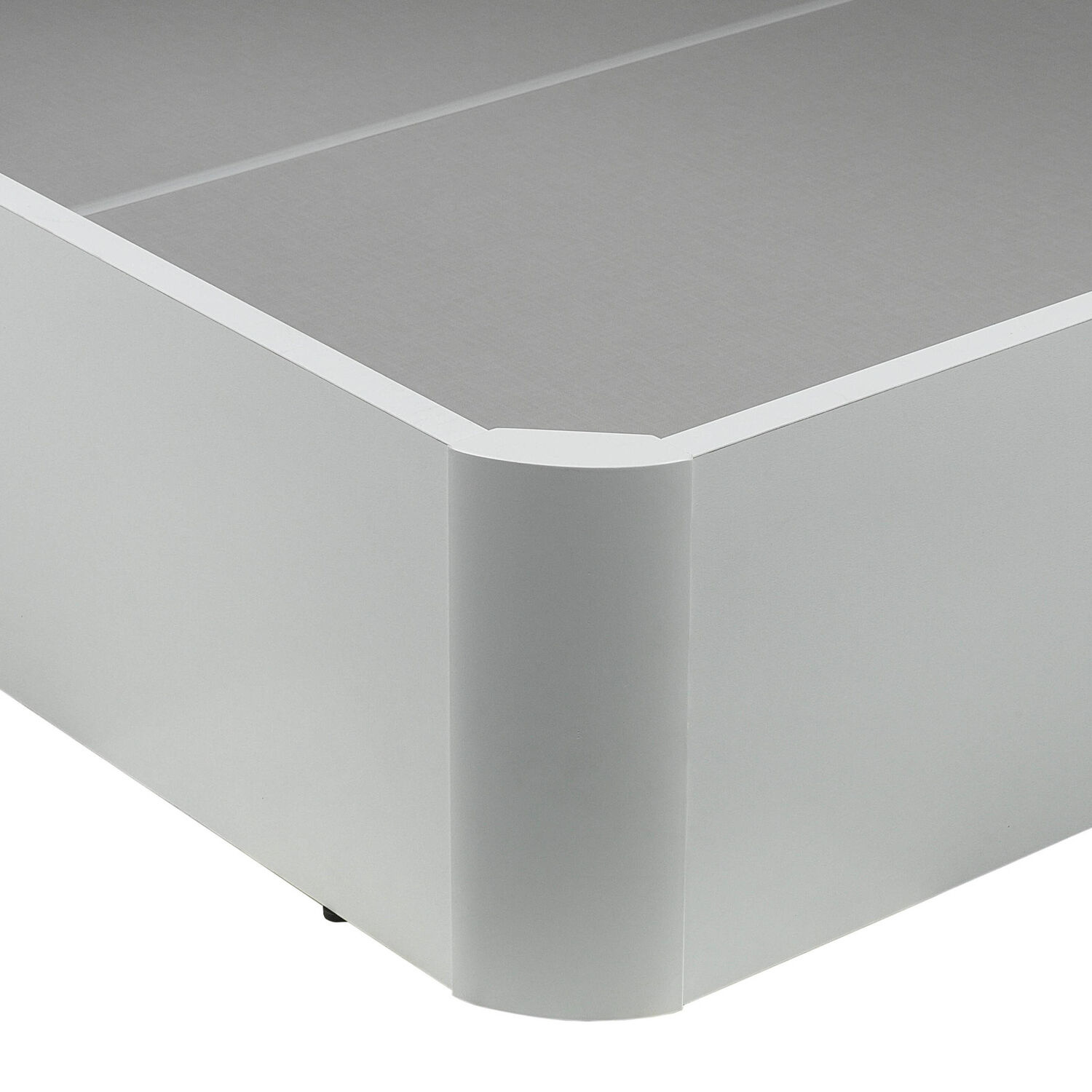 Primer plano de una base de cama blanca con superficie texturizada gris y esquina redondeada.