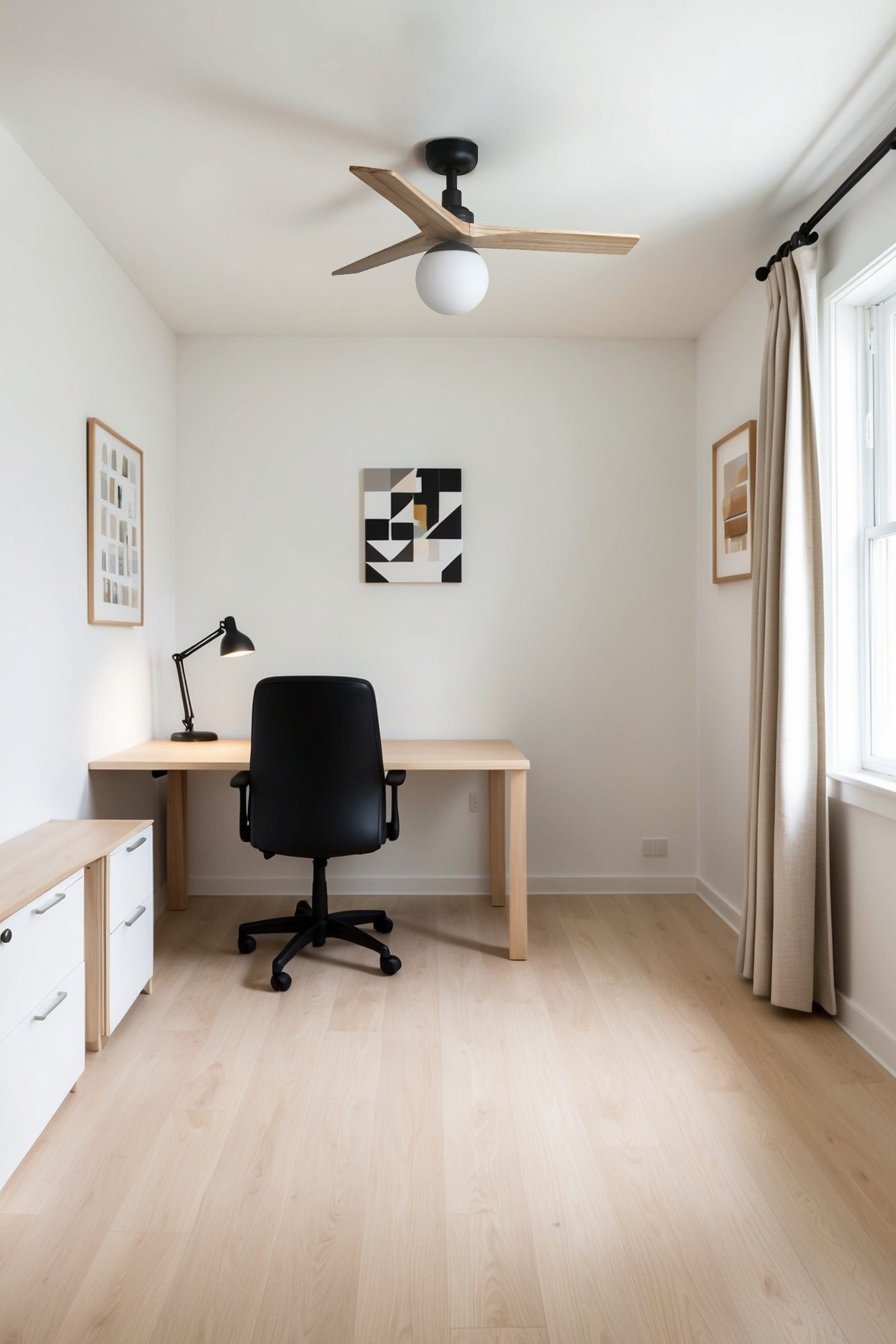 Scrivania con sedia da ufficio nera, lampada, opera d'arte e ventilatore a soffitto.