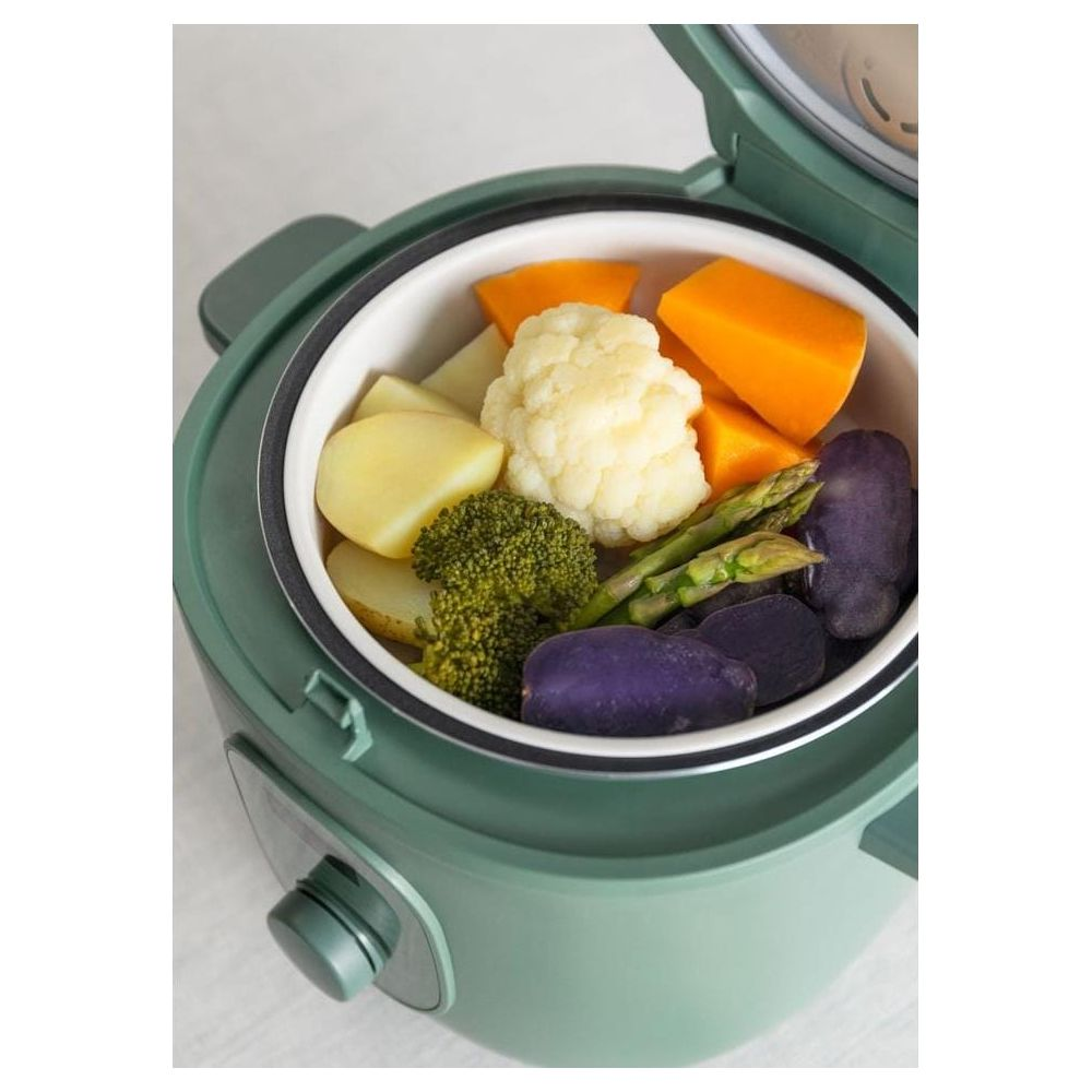 Vaporera verde con varias verduras, incluidas patatas, brócoli, coliflor y calabaza.