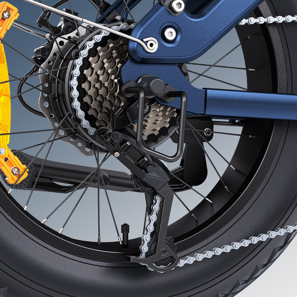 Primer plano del desviador y cassette de una bicicleta azul, con neumático ancho.
