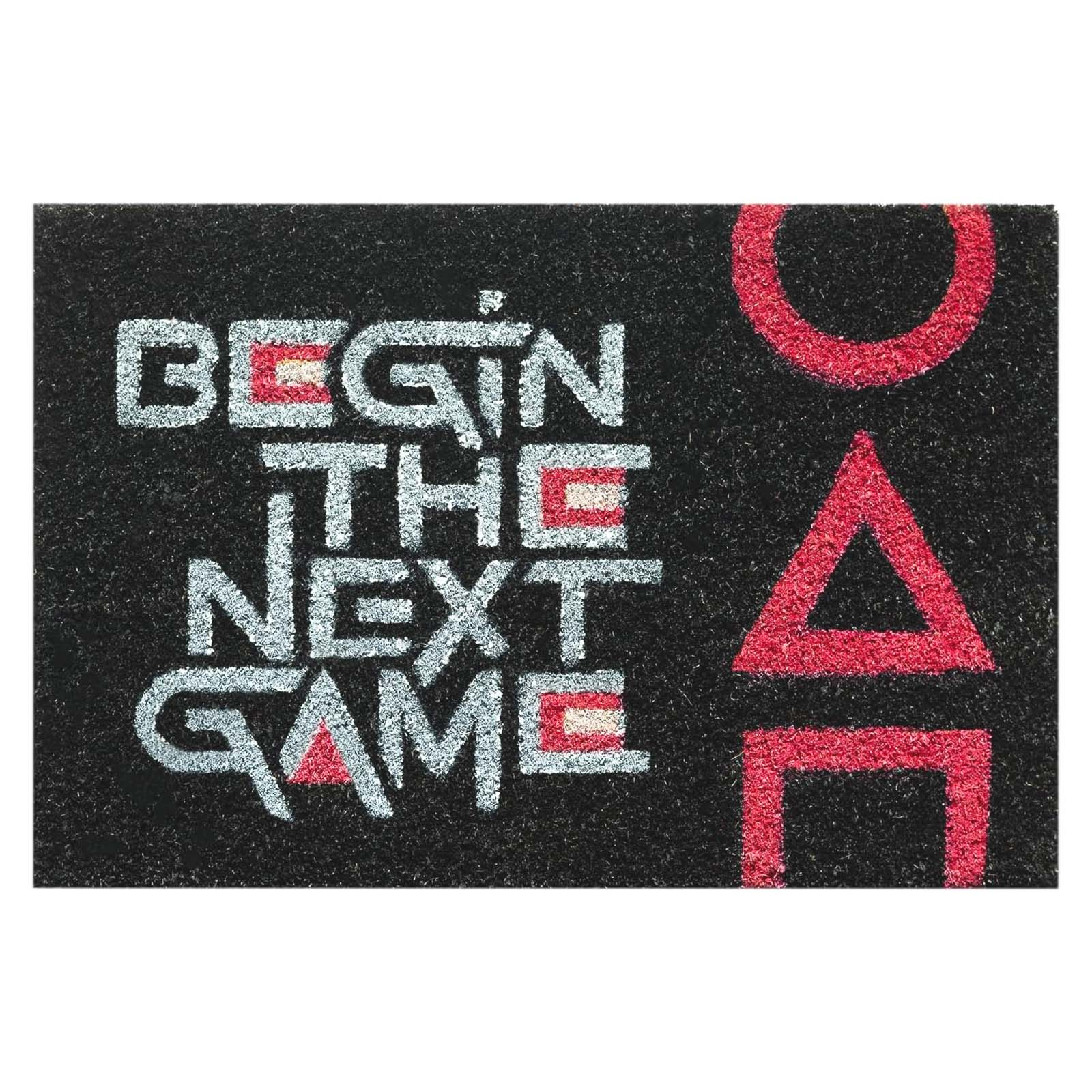 Tappetino nero con scritta "BEGIN THE NEXT GAME" e simboli rossi.