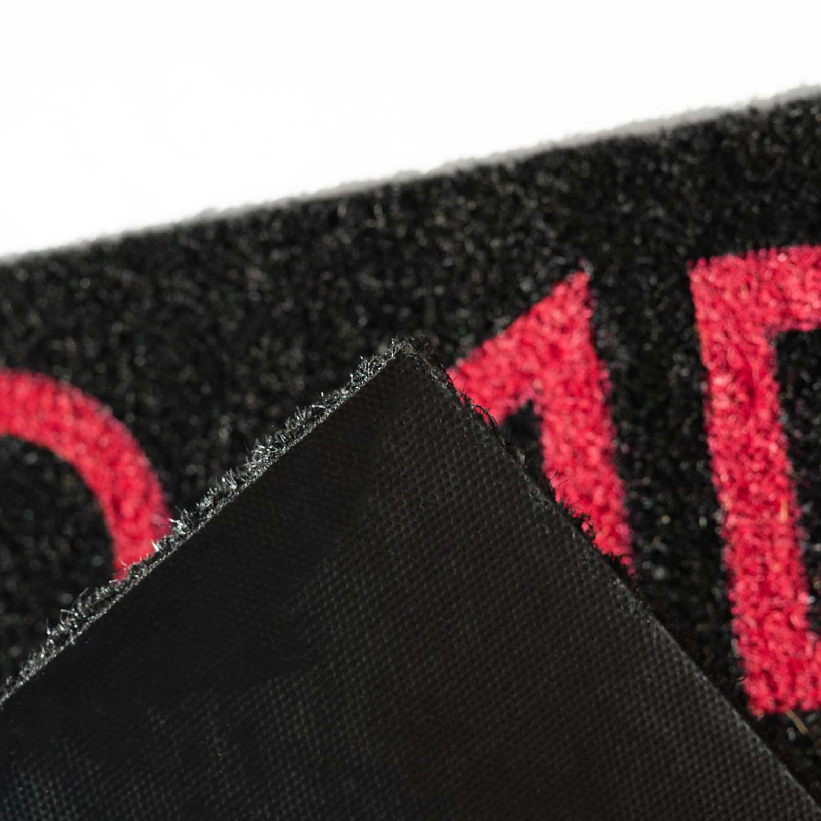 Primo piano di uno zerbino nero con scritte rosse.