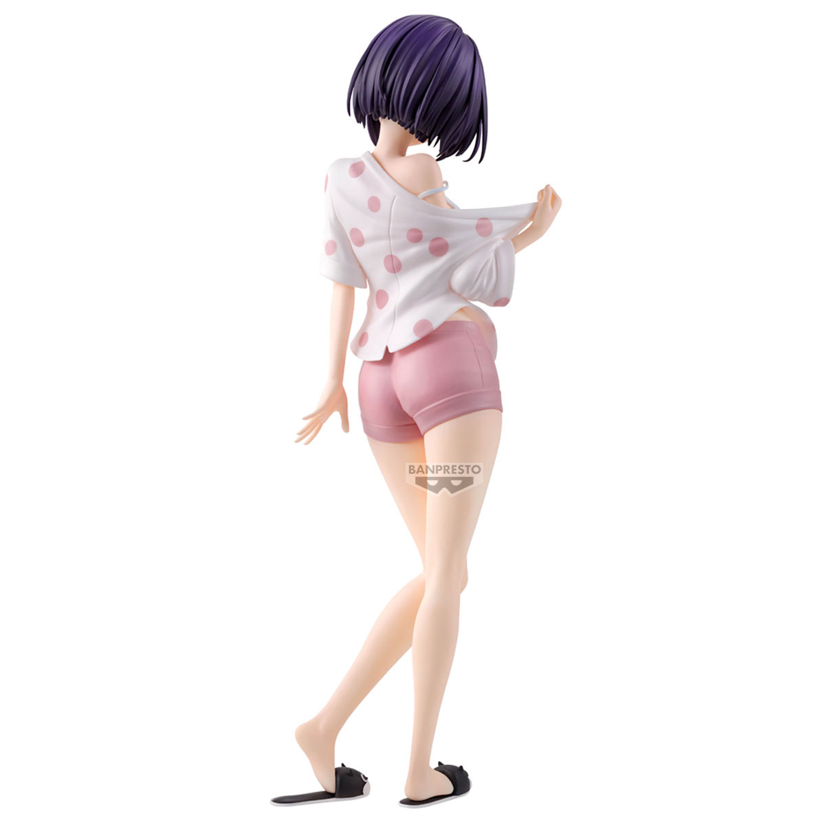 Una figura in top bianco a pois e pantaloncini rosa, vista da dietro.