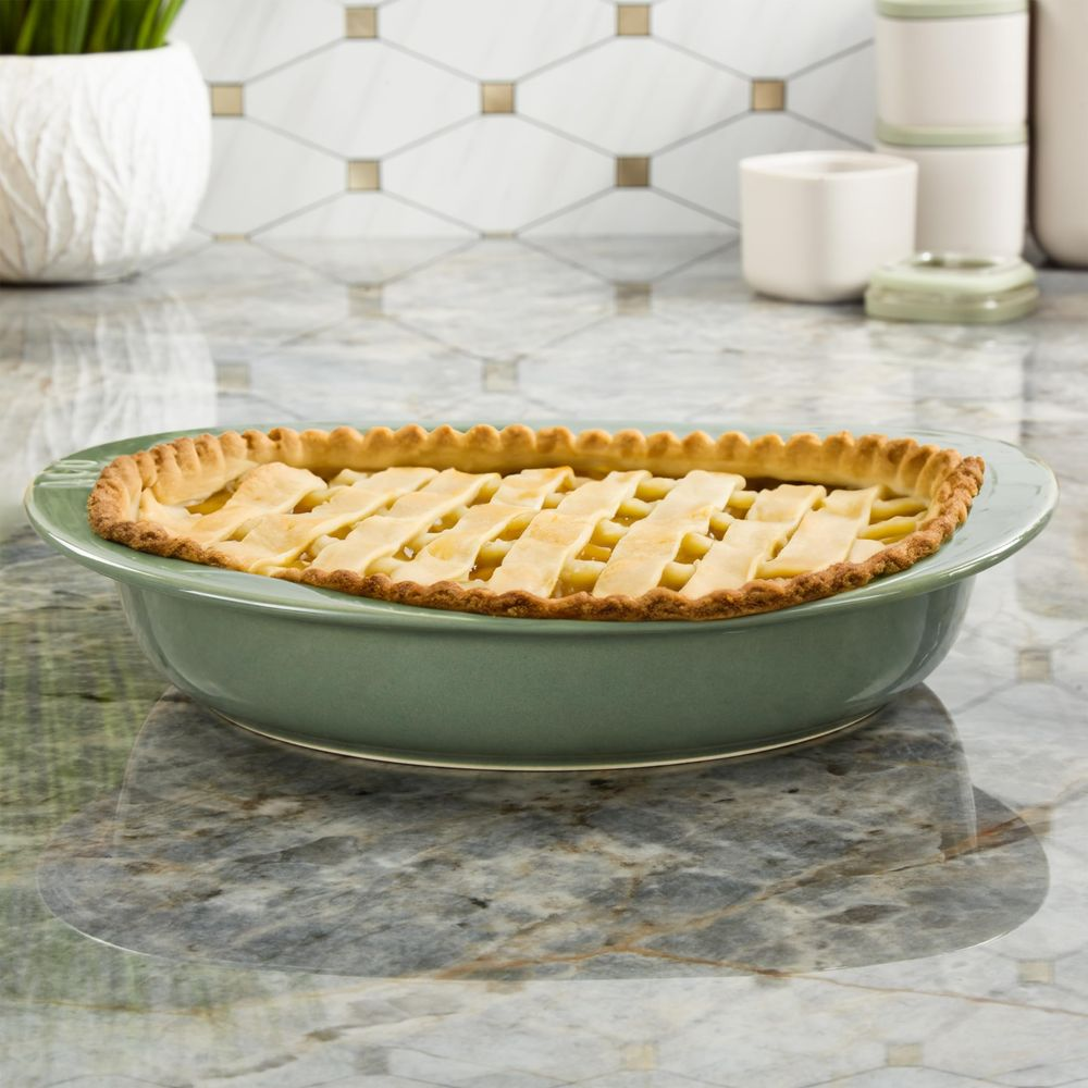 Ein grüner Kuchen mit Gittermuster aus Teig, gefüllt mit Obst.