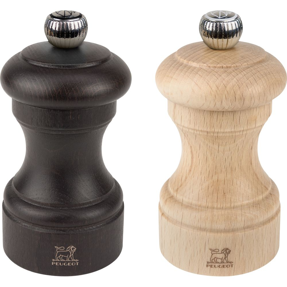Due macinapepe in legno, uno marrone scuro, uno naturale, con cappuccio metallico.