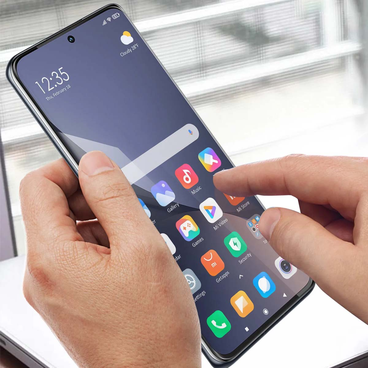 Handen houden een smartphone vast met veel app-iconen op het scherm.
