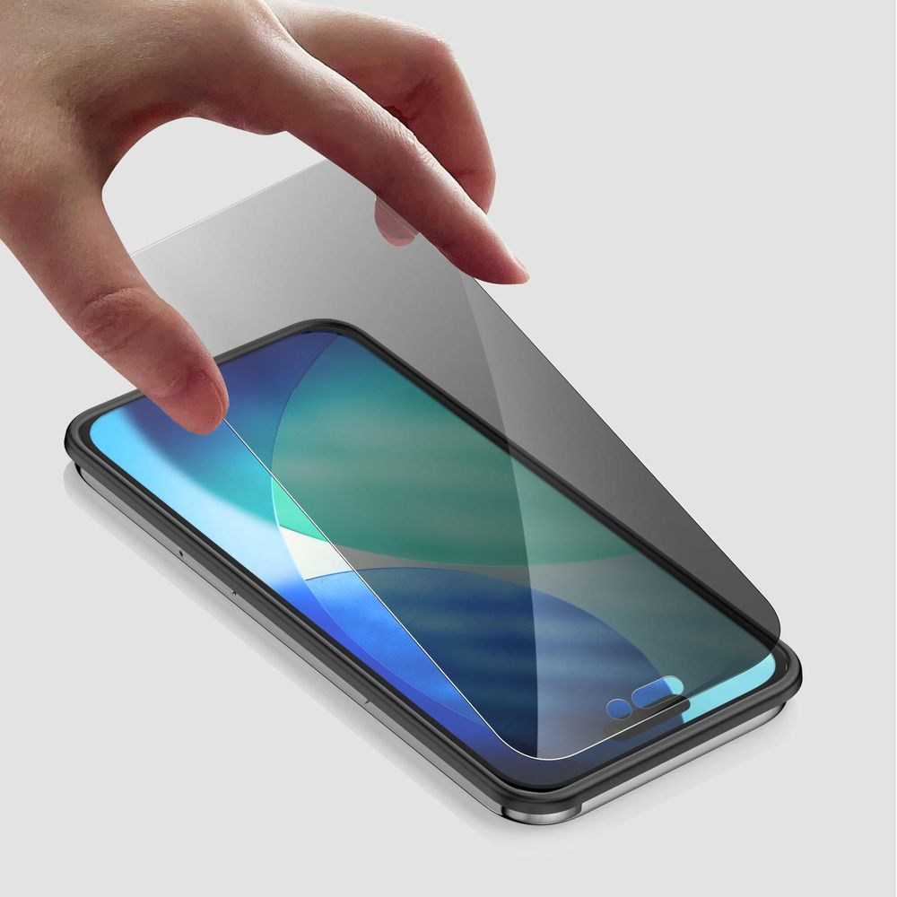 A hand places a screen protector onto a smartphone with a blue and green wallpaper.