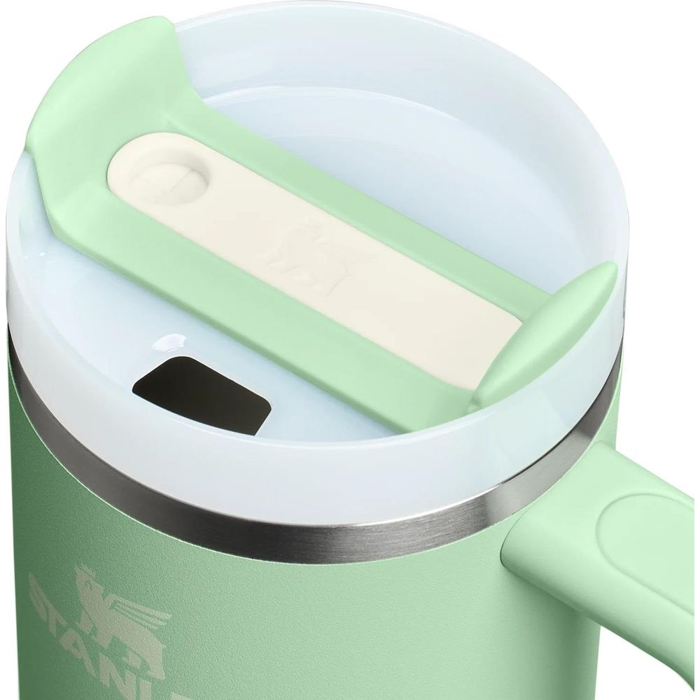 Grüne Thermoskanne mit weißem Deckel und silbernem Ring, Nahaufnahme.