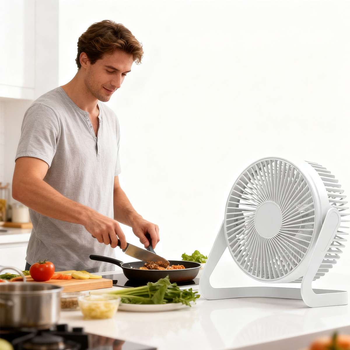 Mann kocht in einer Pfanne, während ein weißer Ventilator daneben steht.