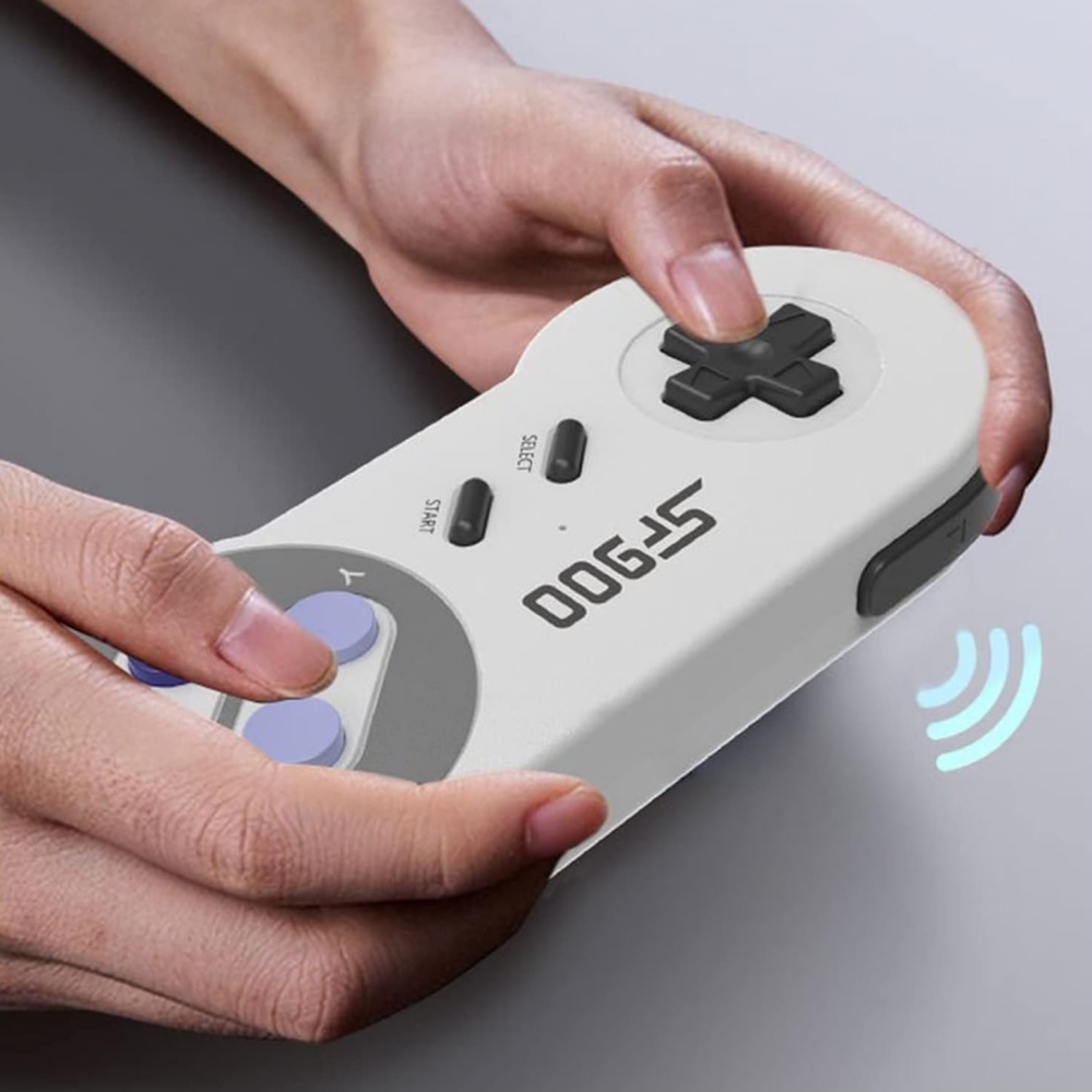 Eine Person hält einen weißen Controller mit schwarzen Knöpfen und lila Akzenten.