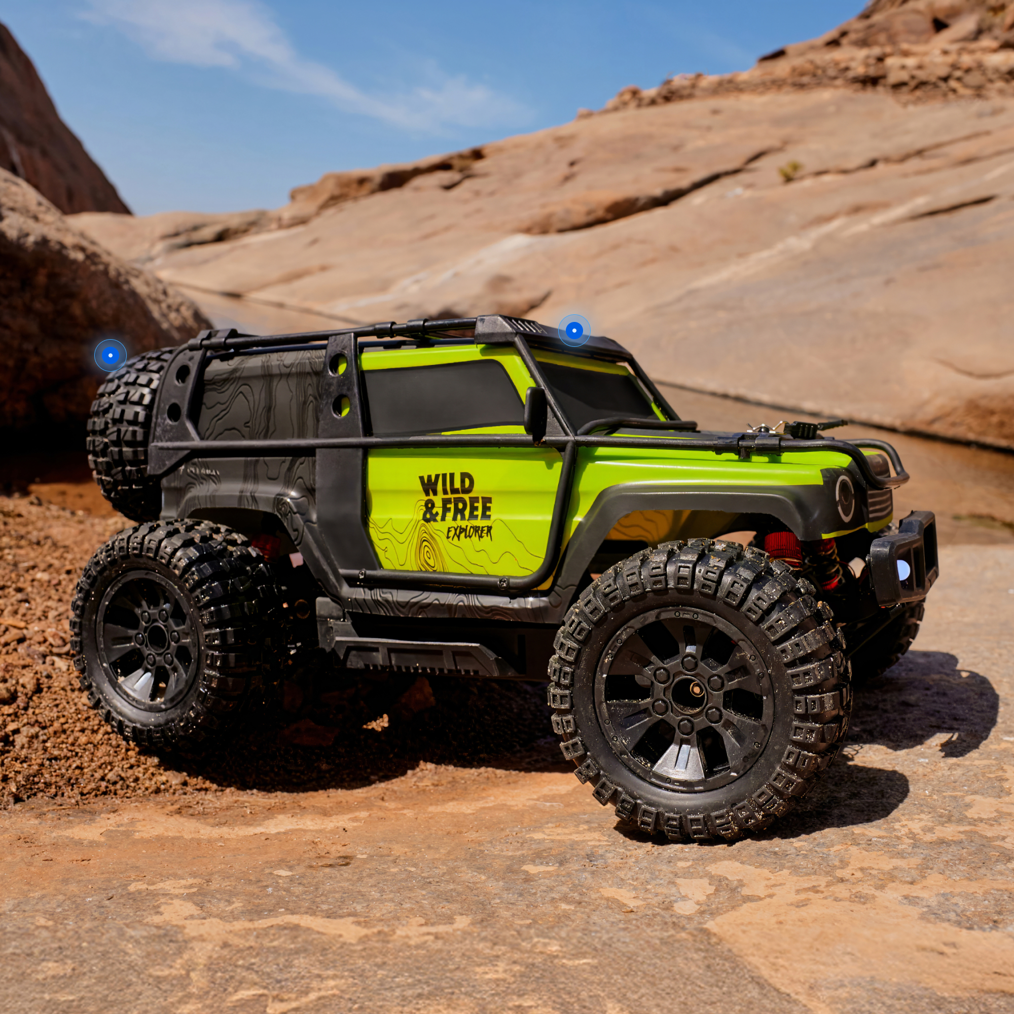 Ein grünes Offroad-Spielzeugauto mit schwarzen Akzenten steht auf felsigem Wüstengrund.
