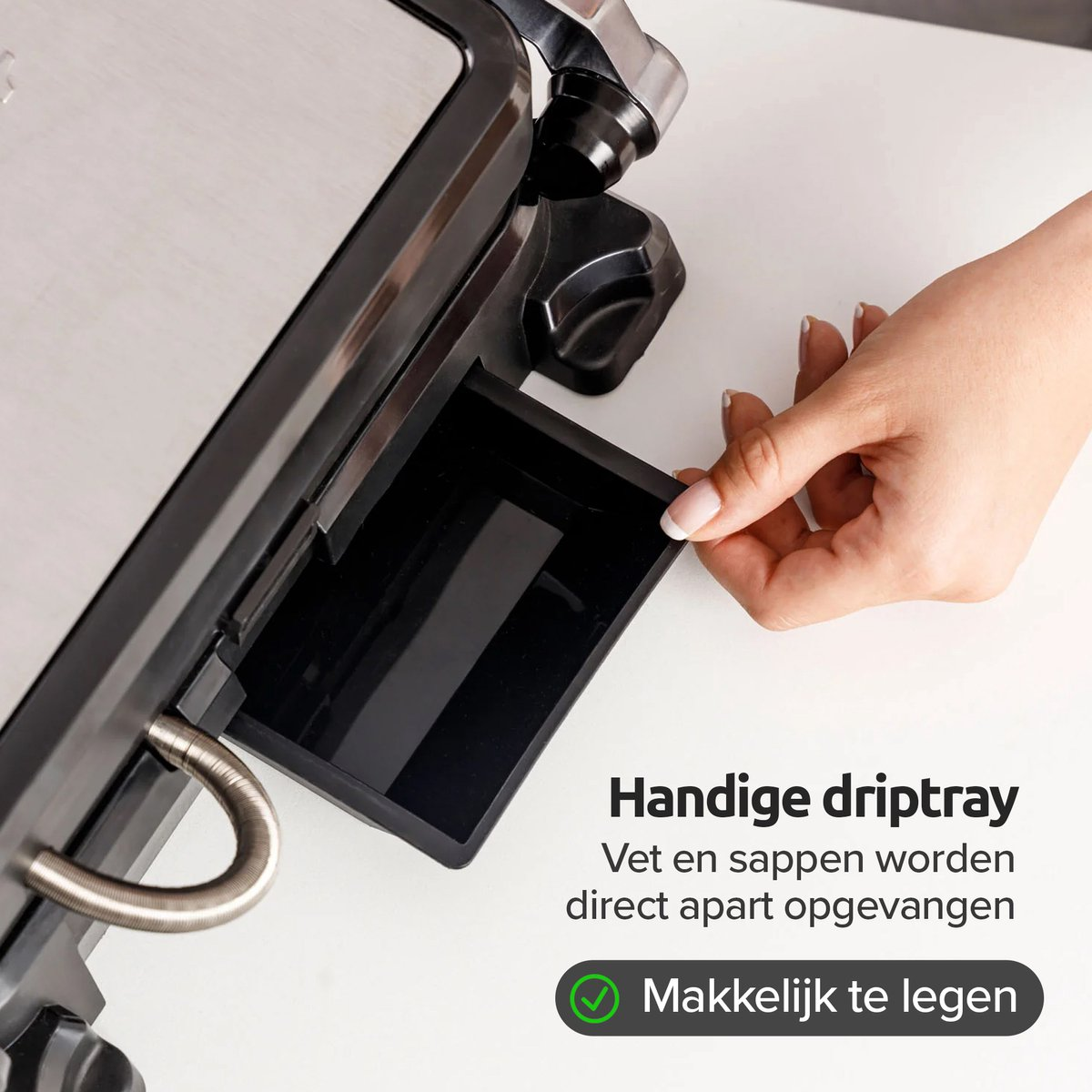 Hand trekt een zwarte plastic uitneembare lekbak eruit.