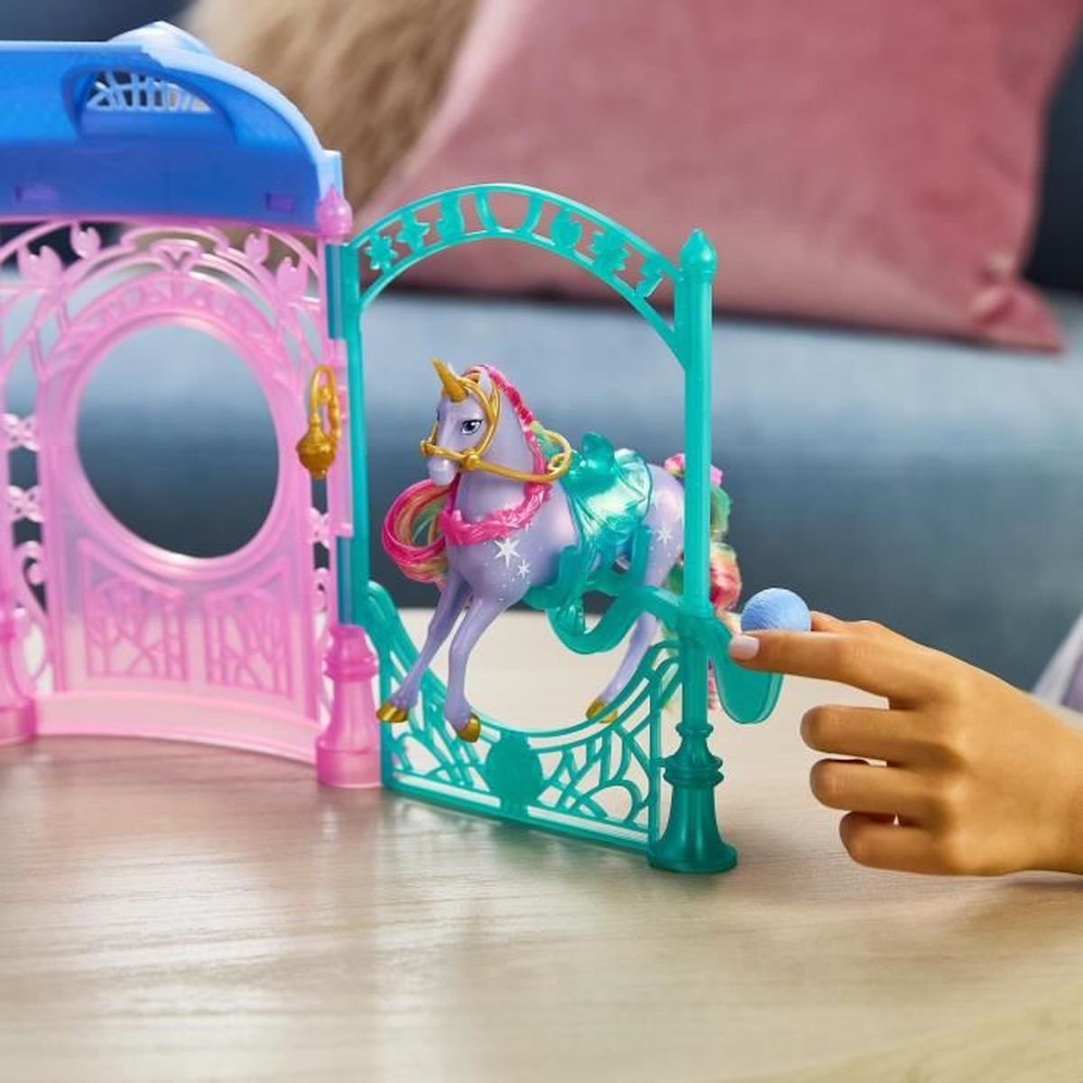 Ein lila Einhorn mit Regenbogenmähne steht vor einem Spielzeughaus.