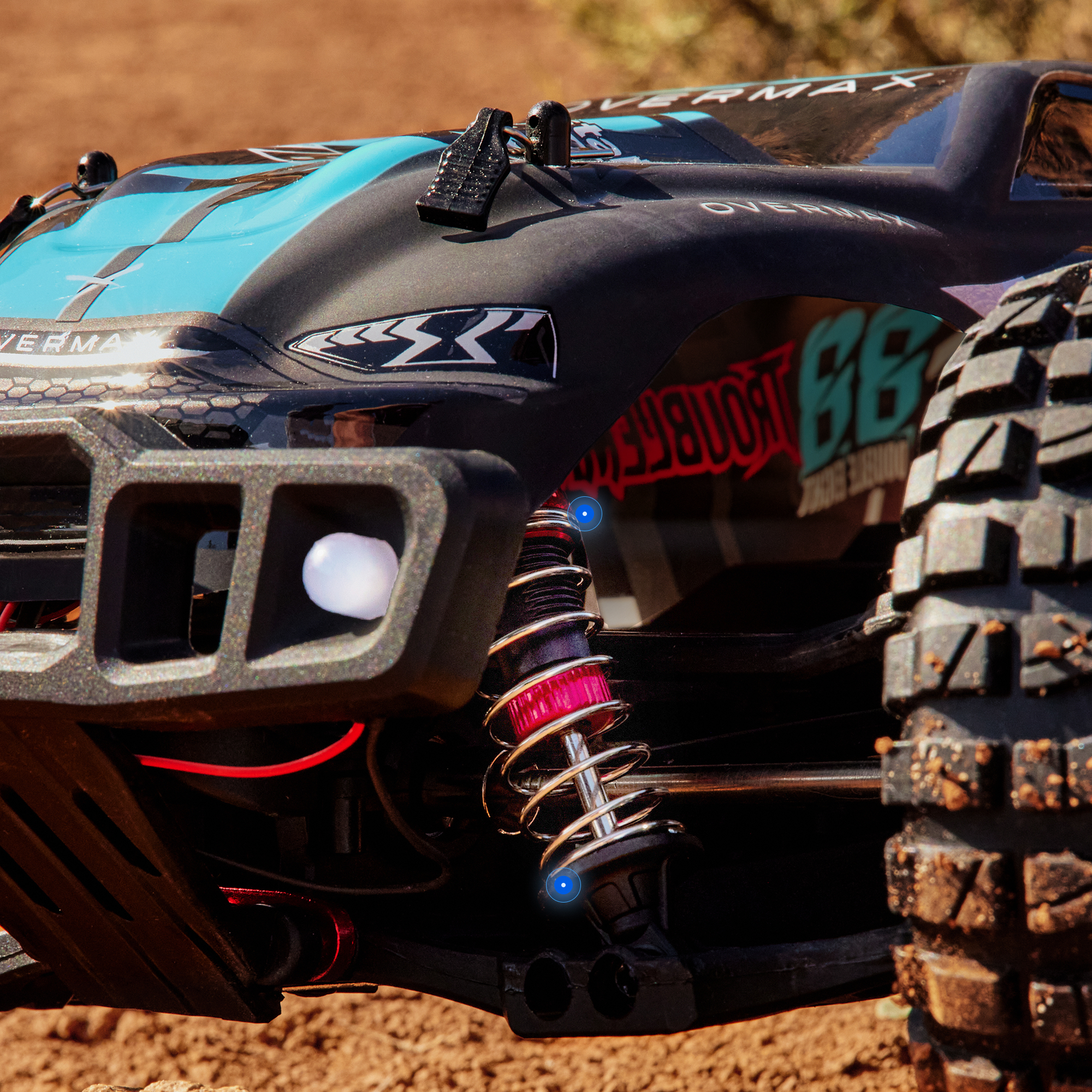 Ein RC-Buggy mit blauen und schwarzen Streifen auf schmutzigem Boden.