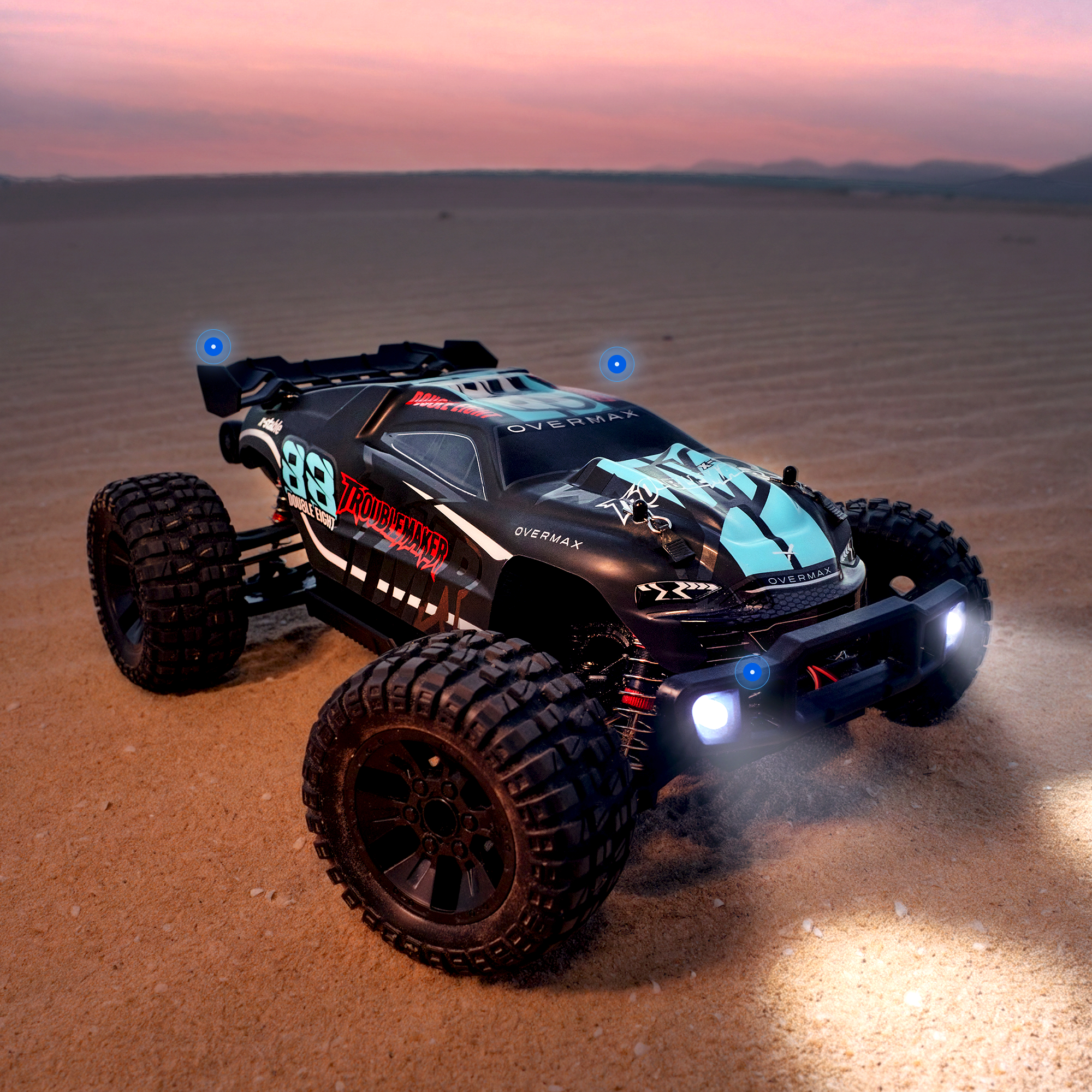 Ein schwarzer RC-Buggy mit blauen Lichtern auf sandigem Boden bei Sonnenuntergang.