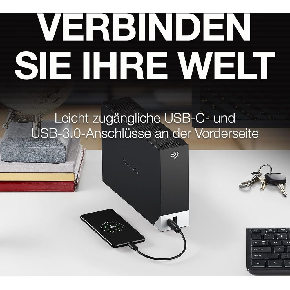 Schwarze externe Festplatte mit USB-C- und USB-3.0-Anschlüssen, lädt Smartphone.