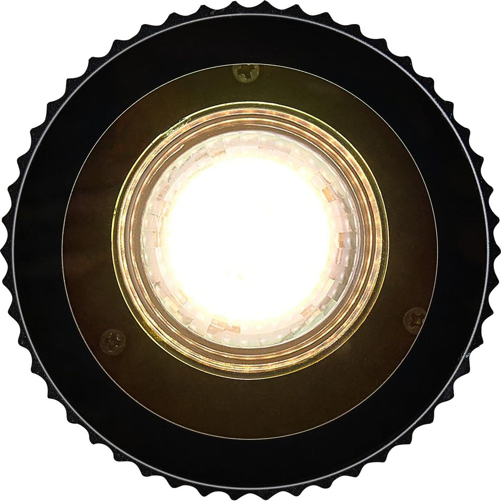 Primo piano di una lampadina a LED luminosa con alloggiamento nero seghettato.