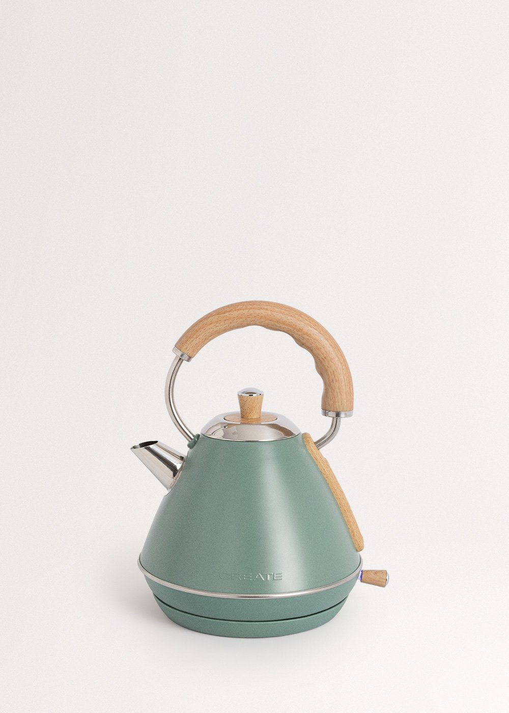 Una tetera verde con mango de madera y detalles plateados sobre fondo blanco.
