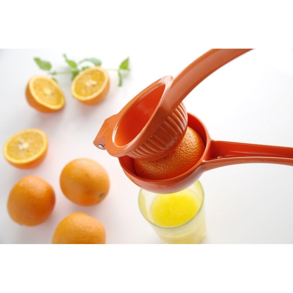 Uno spremiagrumi arancione spremi un'arancia sopra un bicchiere di succo.