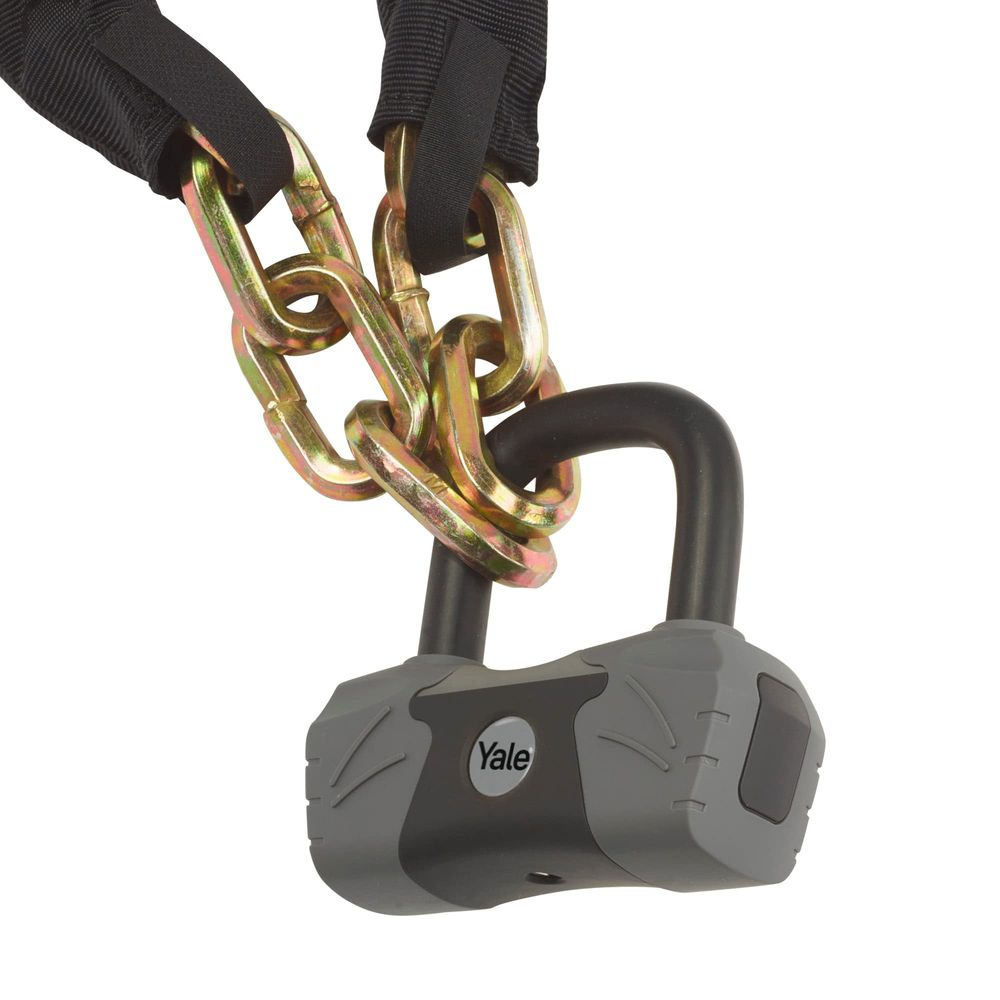 Un candado Yale resistente con una gruesa cadena de metal, asegurado con una funda de tela negra.