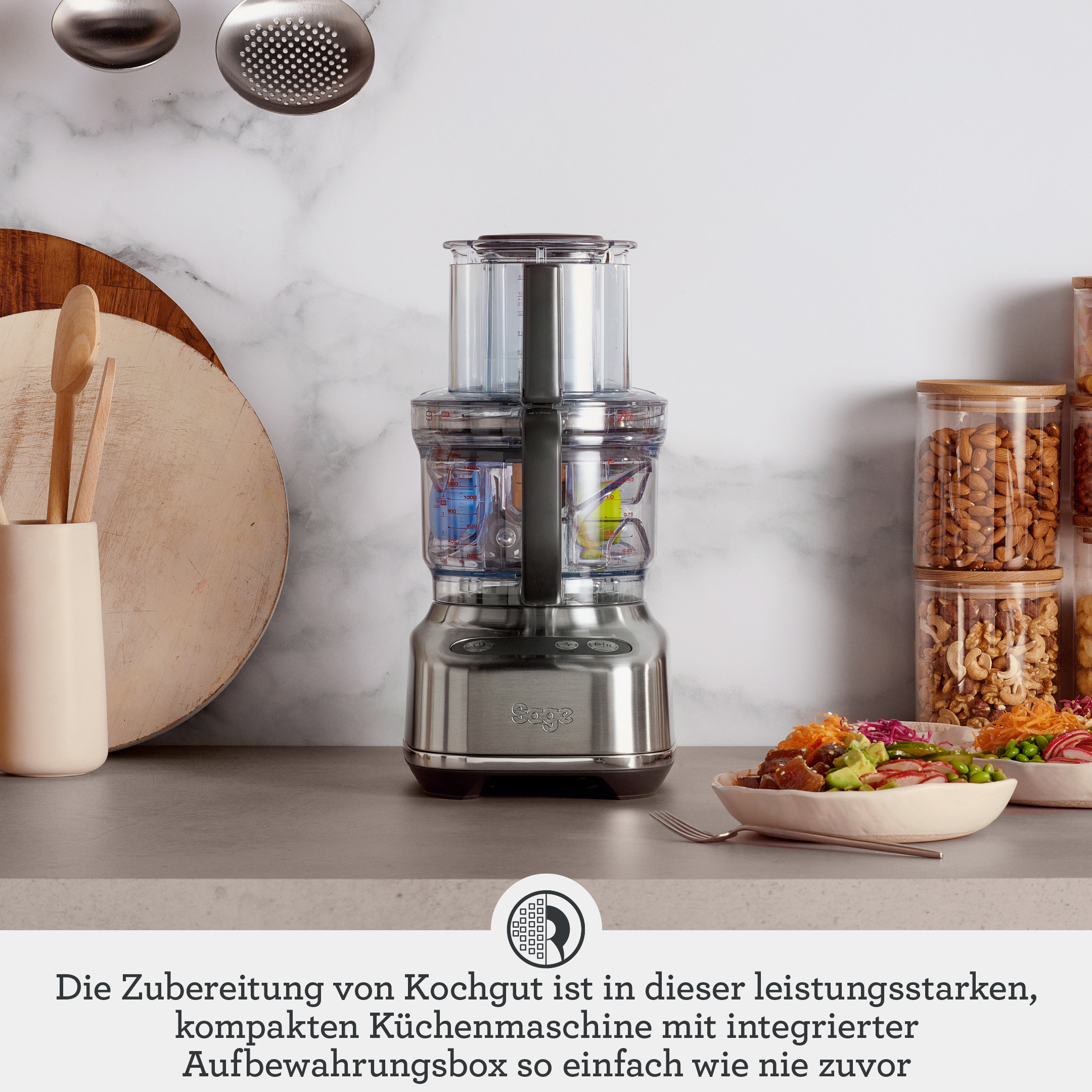 Edelstahl-Küchenmaschine mit Zubehör, Schüsseln und Zutaten.