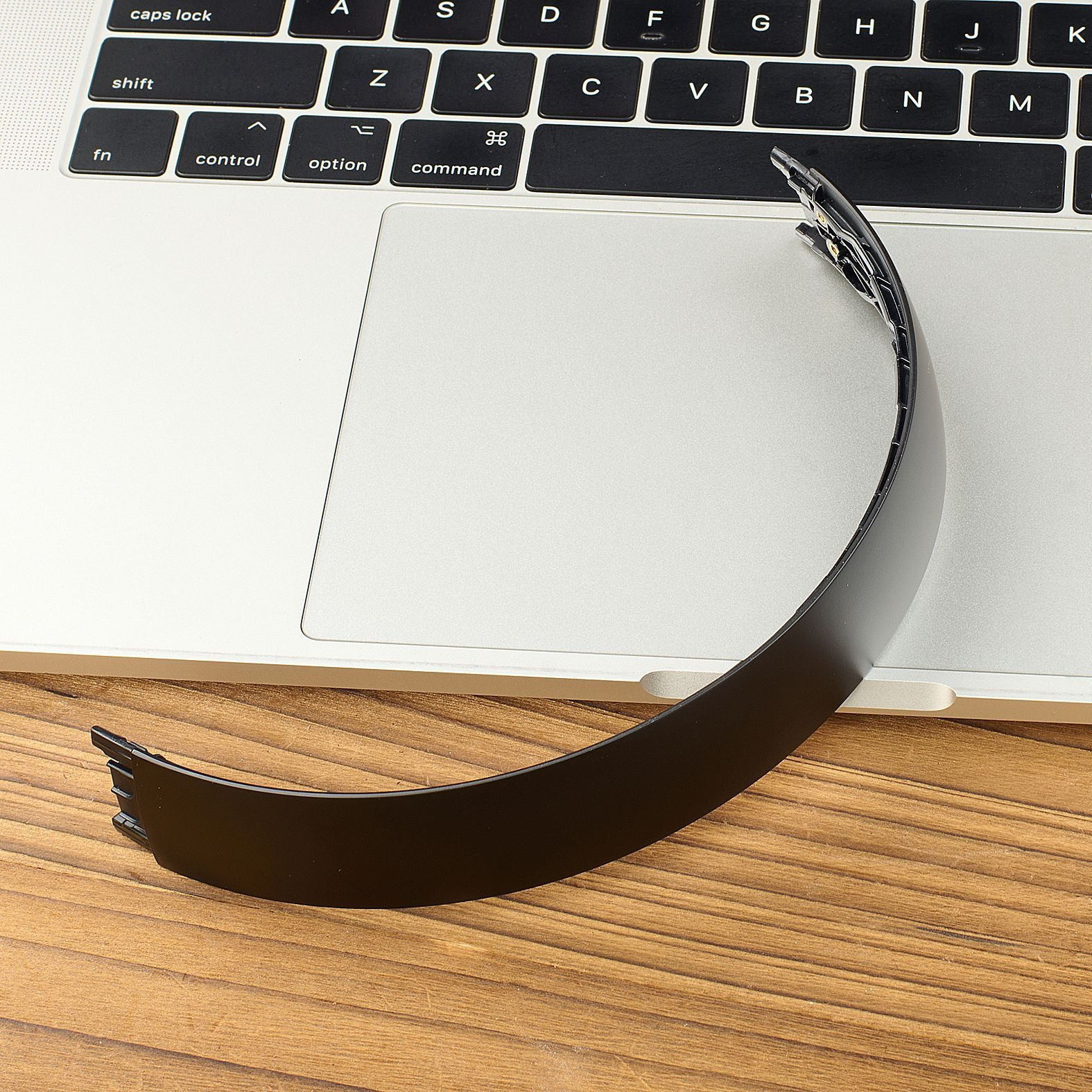 Cinturino nero su laptop e tavolo di legno.
