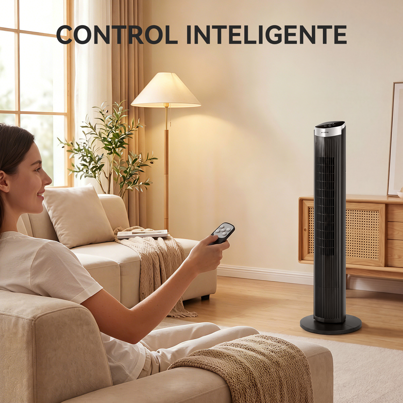 Frau auf Sofa mit Fernbedienung, daneben ein schwarzer Turmventilator.