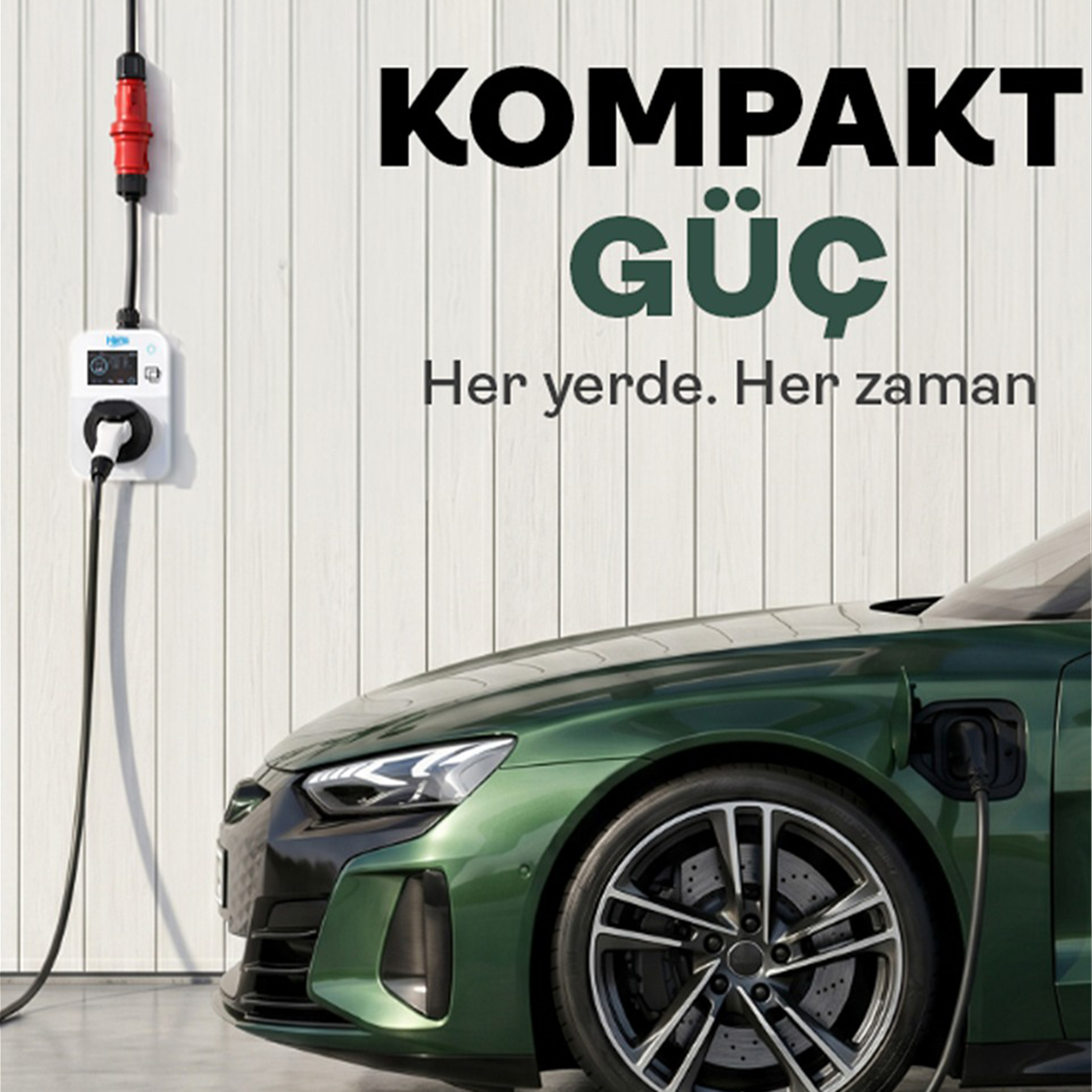 Yeşil bir elektrikli araba, üzerinde yazı bulunan beyaz bir duvarda şarj oluyor.